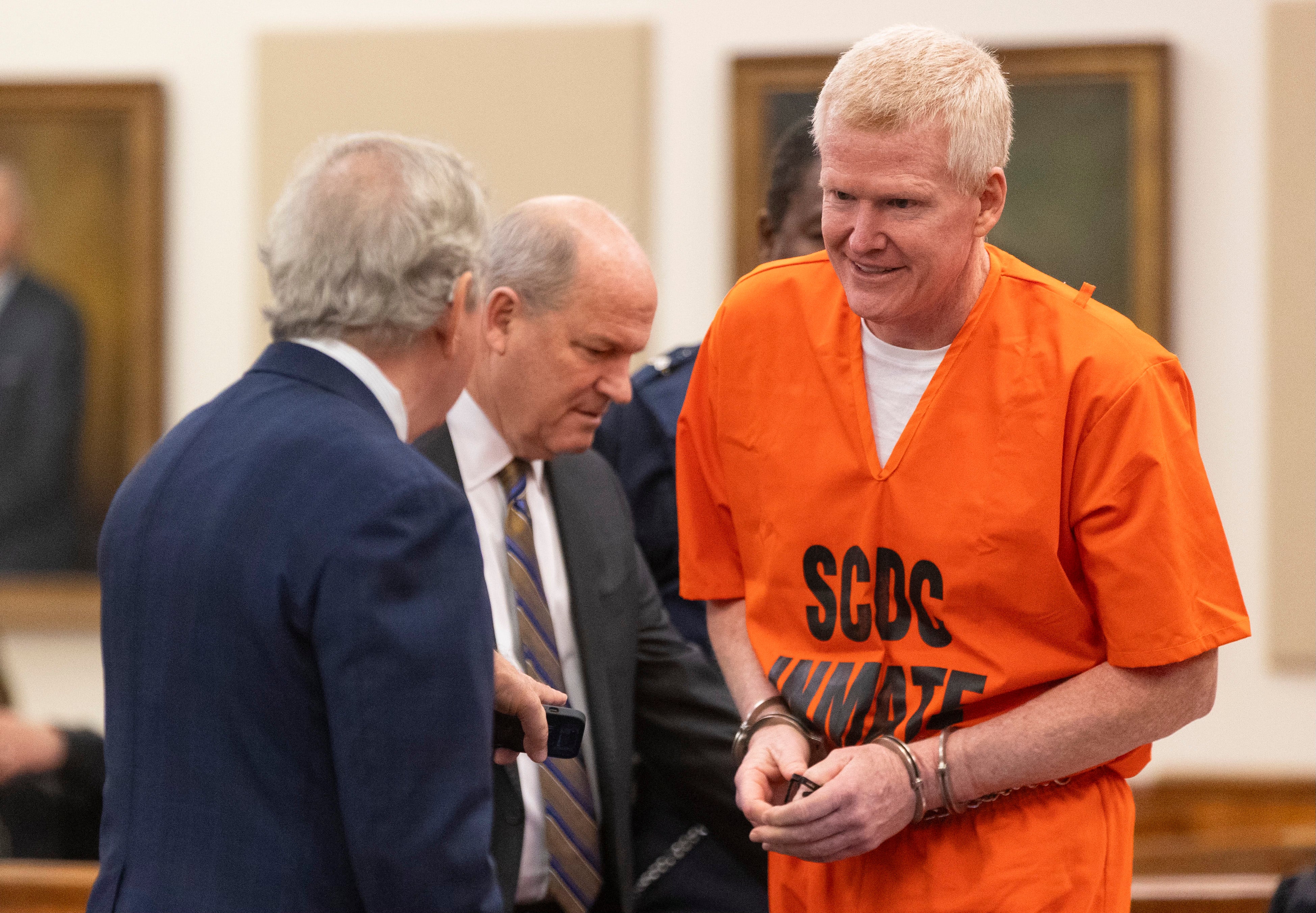 Alex Murdaugh smiles to his attorneys Dick Harpootlian, left, and Jim Griffin, right, as he arrives for his sentencing
