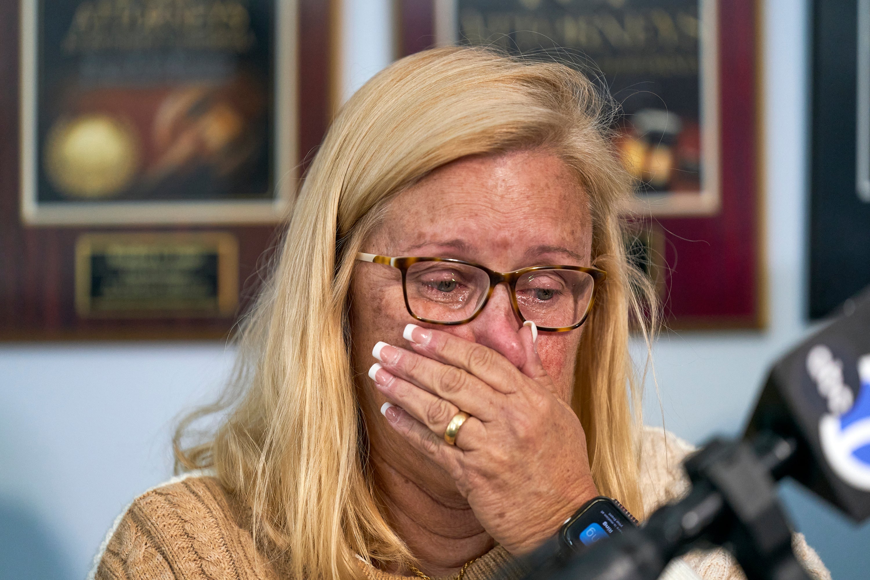 Kim Clinkunbroomer, the mother of late Los Angeles Sheriff's Deputy Ryan Clinkunbroomer, wipes tears as she takes questions from the media after announcing a precursor of a lawsuit against the Sheriff's Department at a news conference in Los Angeles on Tuesday, Nov. 28, 2023.