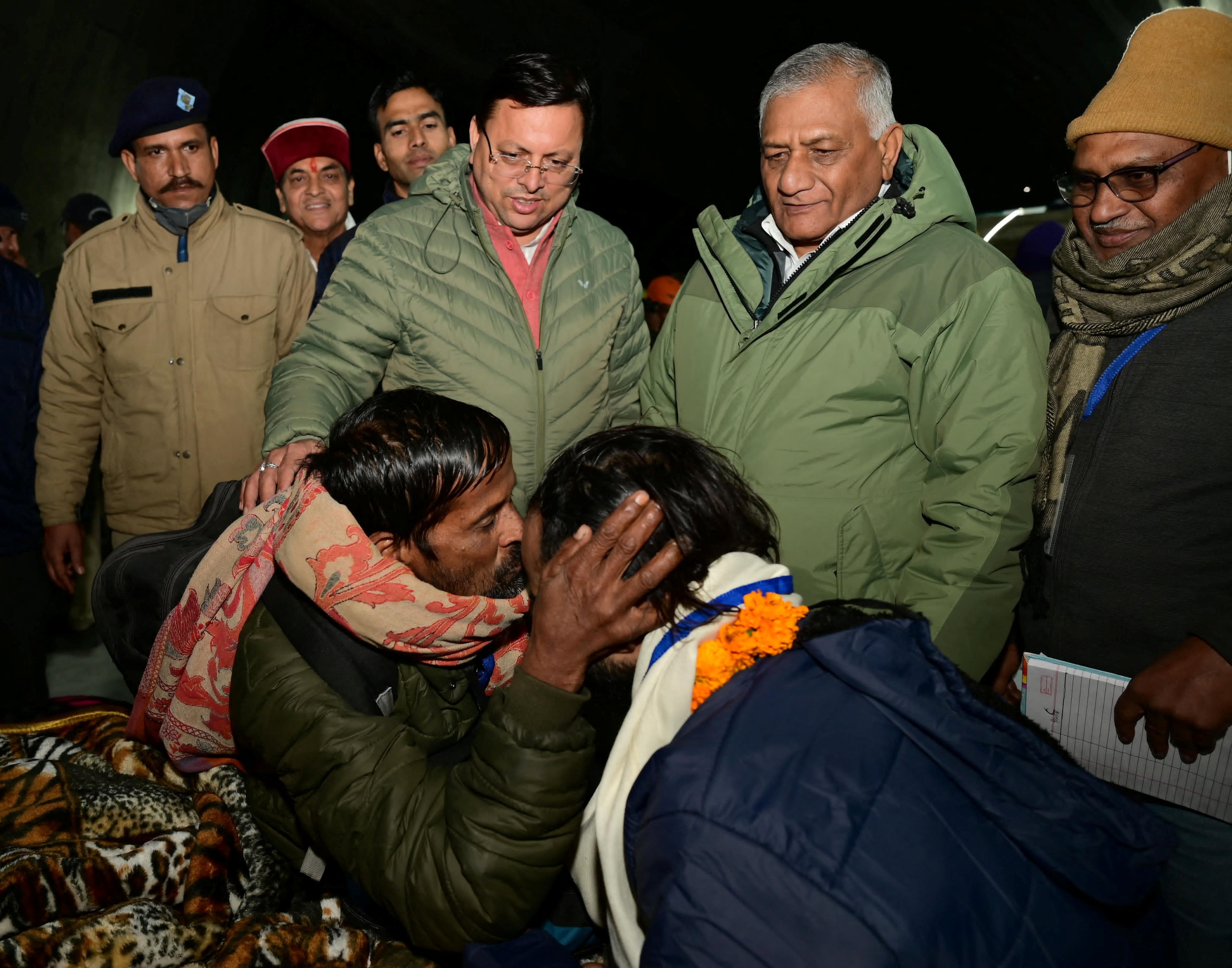 A man kisses a rescued worker after being rescued from the collapsed tunnel site as Pushkar Singh Dhami, Chief Minister of the northern state of Uttarakhand
