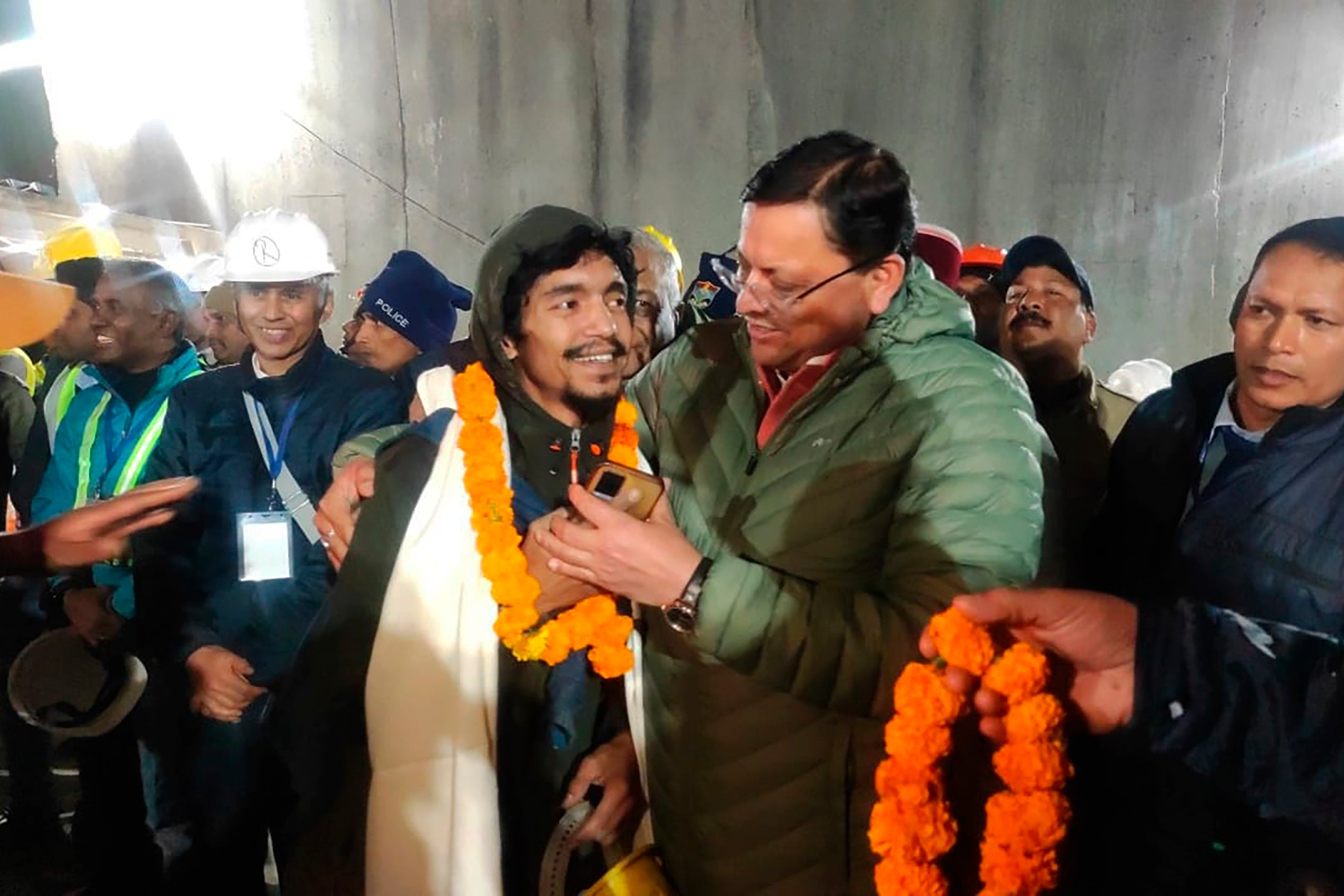Pushkar Singh Dhami greets a worker rescued from the site of an under-construction road tunnel that collapsed