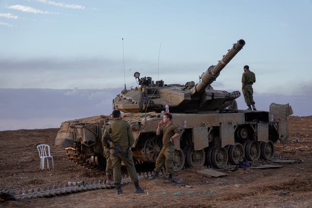 <p>Israeli soldiers work on a tank near the border with the Gaza Strip, southern Israel</p>