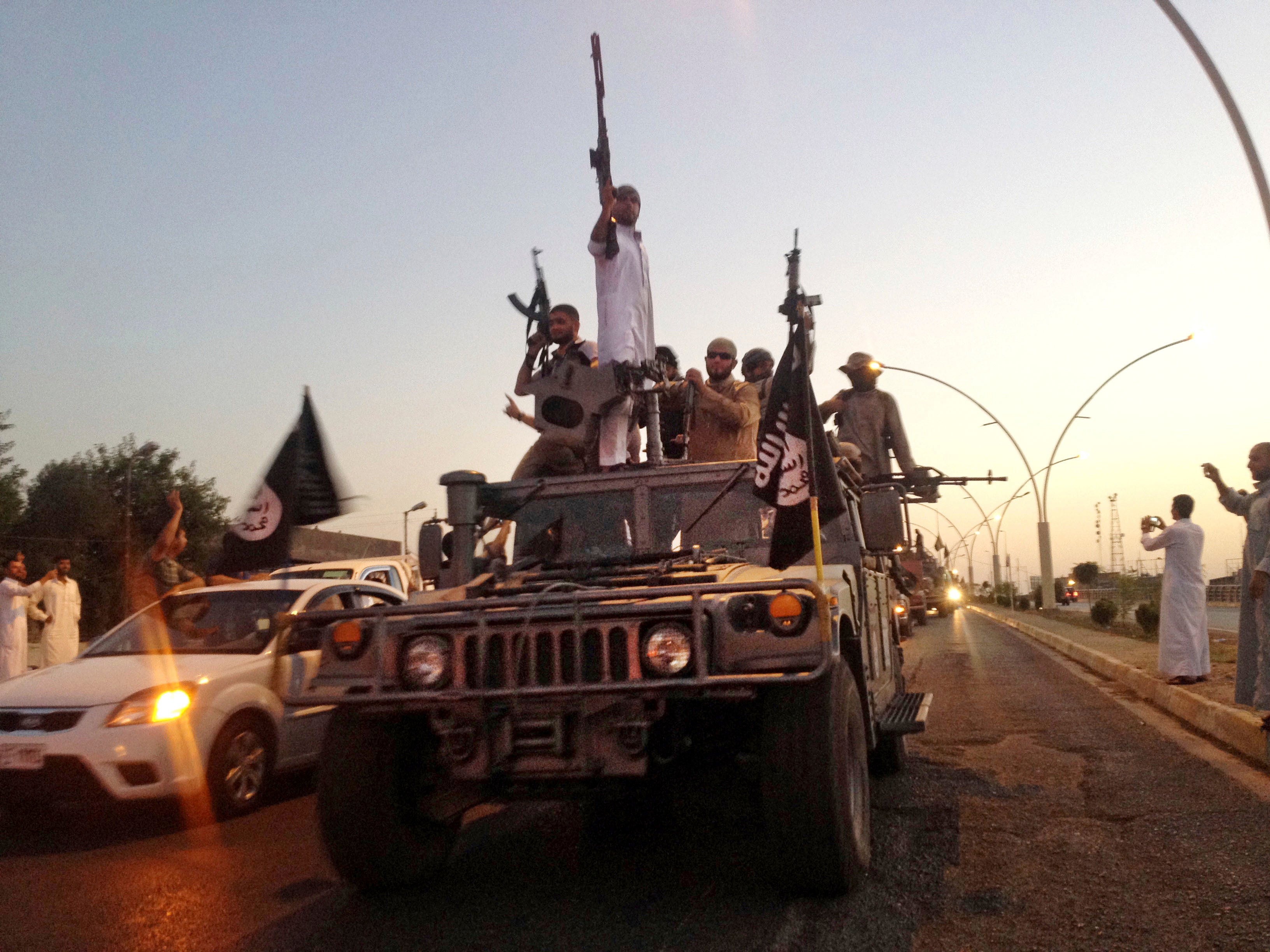 Islamic State fighters parade in a commandeered Iraqi security forces vehicle, Mosul, Iraq, June 2014