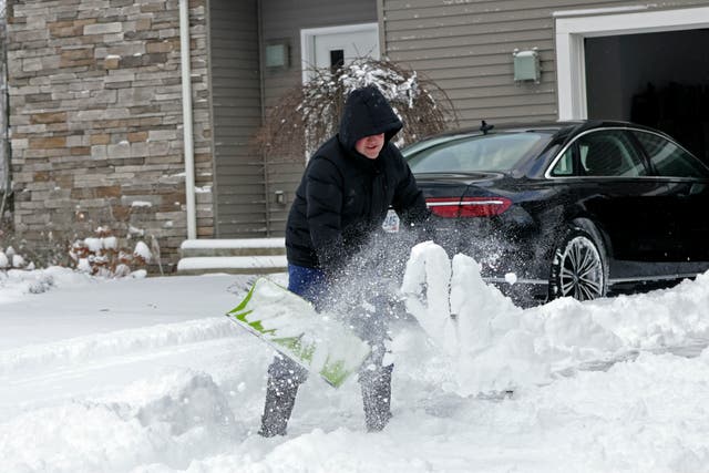 <p>A man shovels snow out of his driveway in Beachwood, Ohio on 28 November after lake-effect snowfall blanketed the region</p>