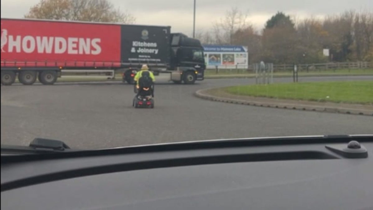 Elderly man zooms across roundabout on his mobility scooter