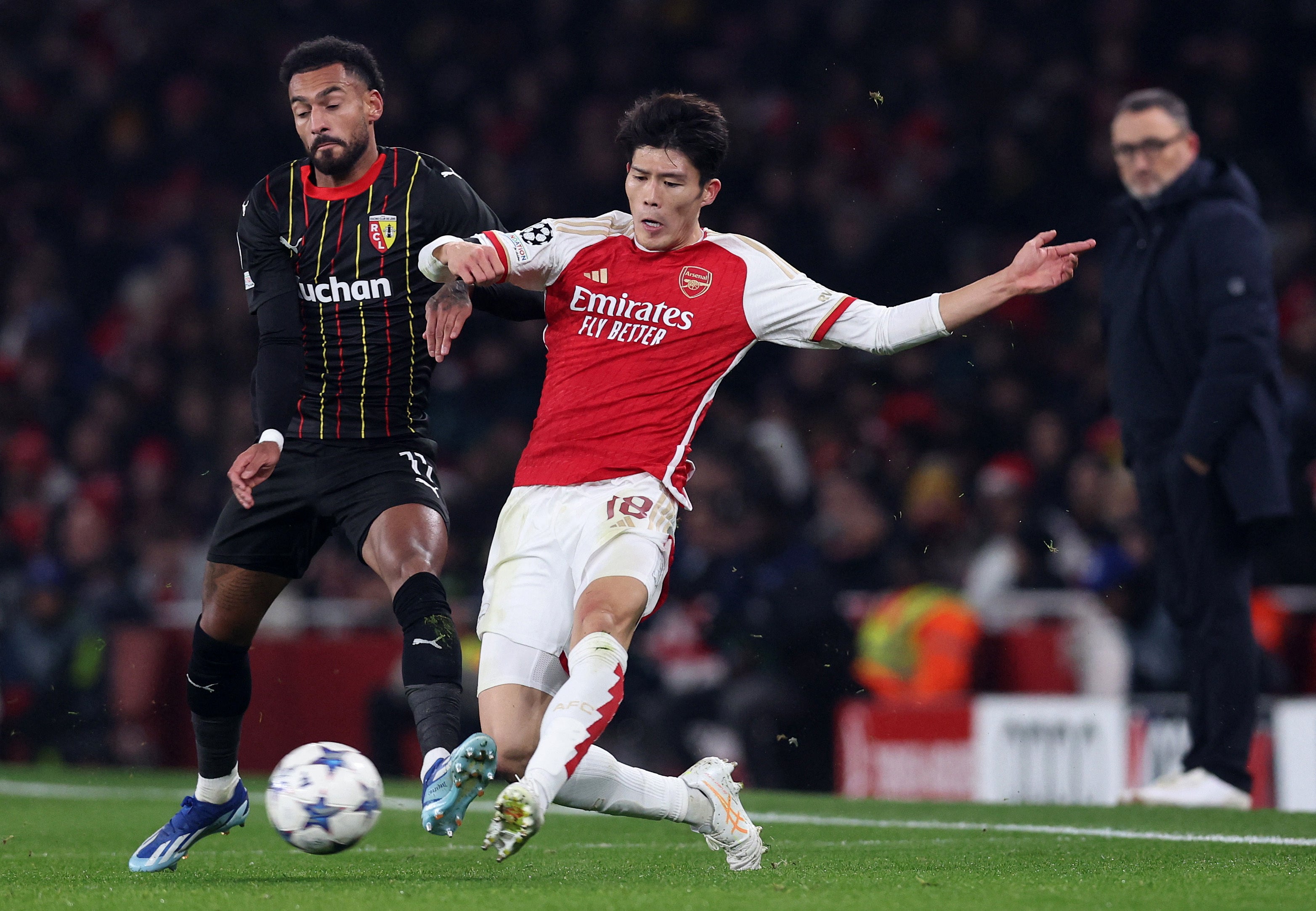 Takehiro Tomiyasu battles for the ball in the Champions League against Lens