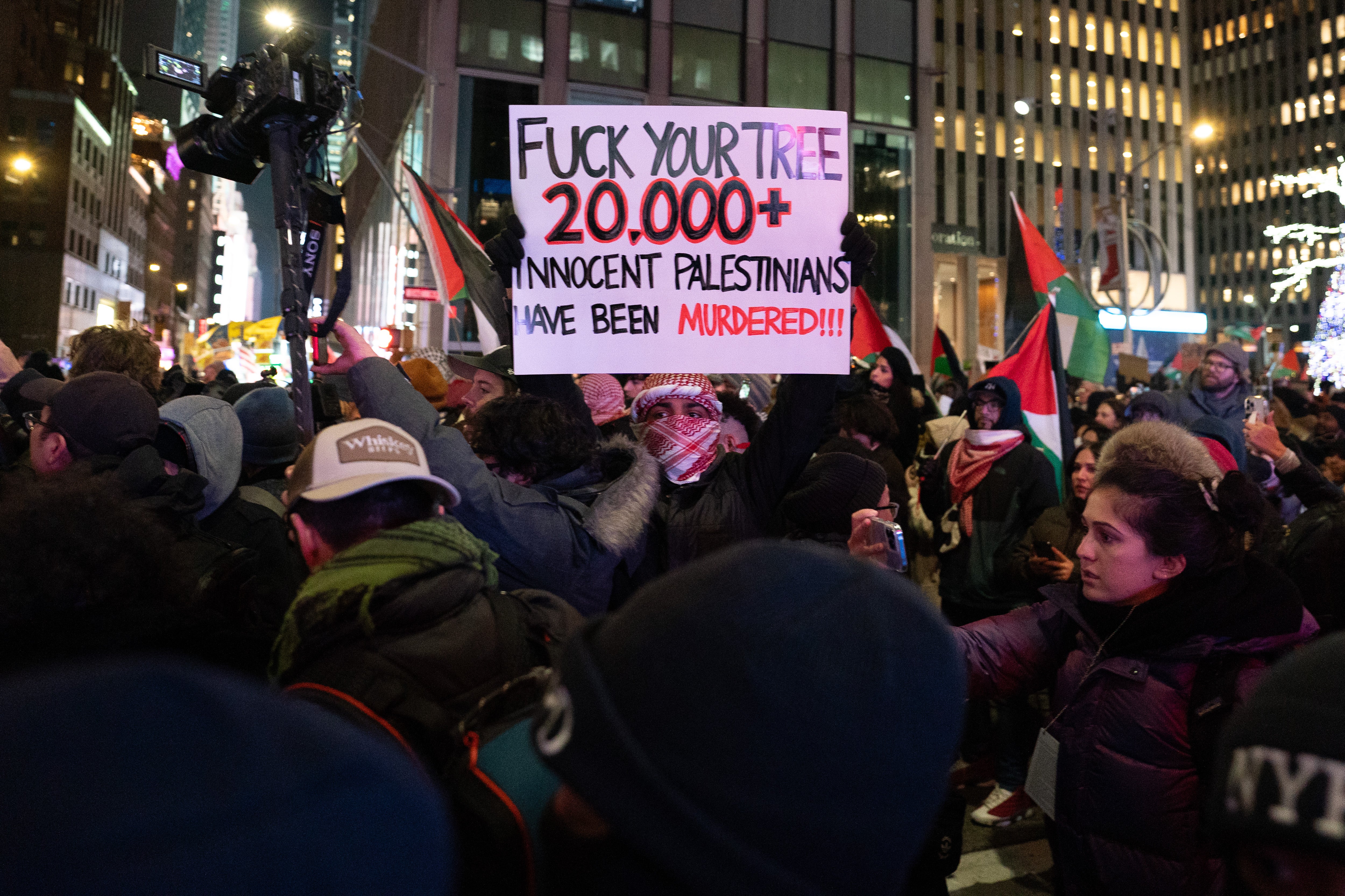 A protestor holding a sign at the ongoing holiday celebration in NYC