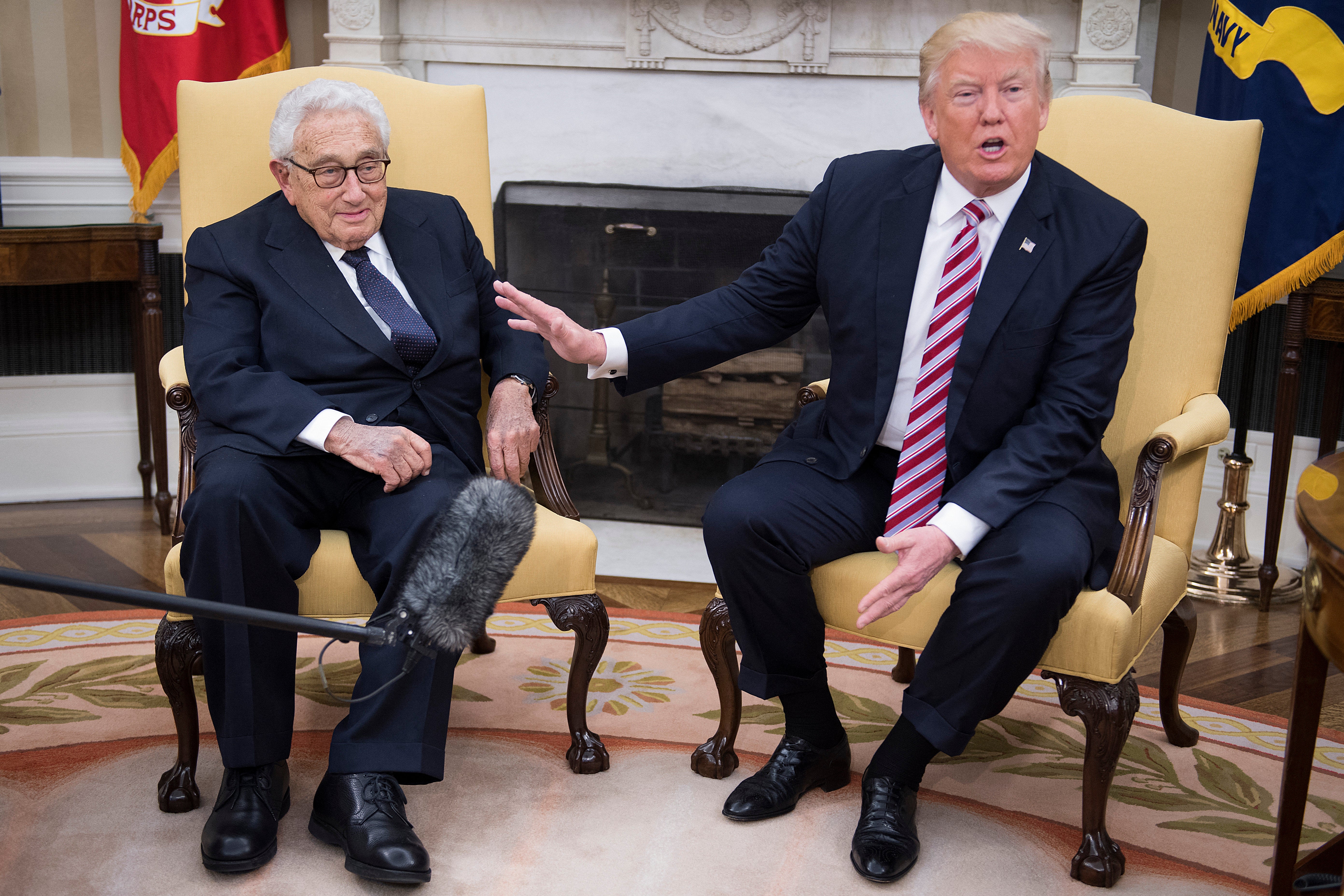 FILES) US President Donald Trump (R) speaks with former US Secretary of State Henry Kissinger during a meeting in the Oval Office in 2017.