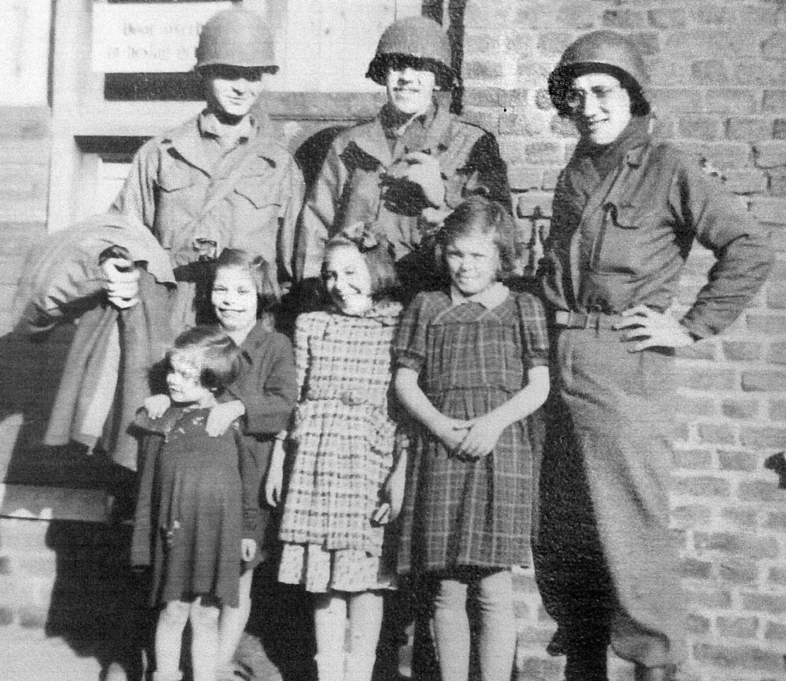 In this undated photo, Kisisnger(far left) is seen standing next to American soldiers and German children
