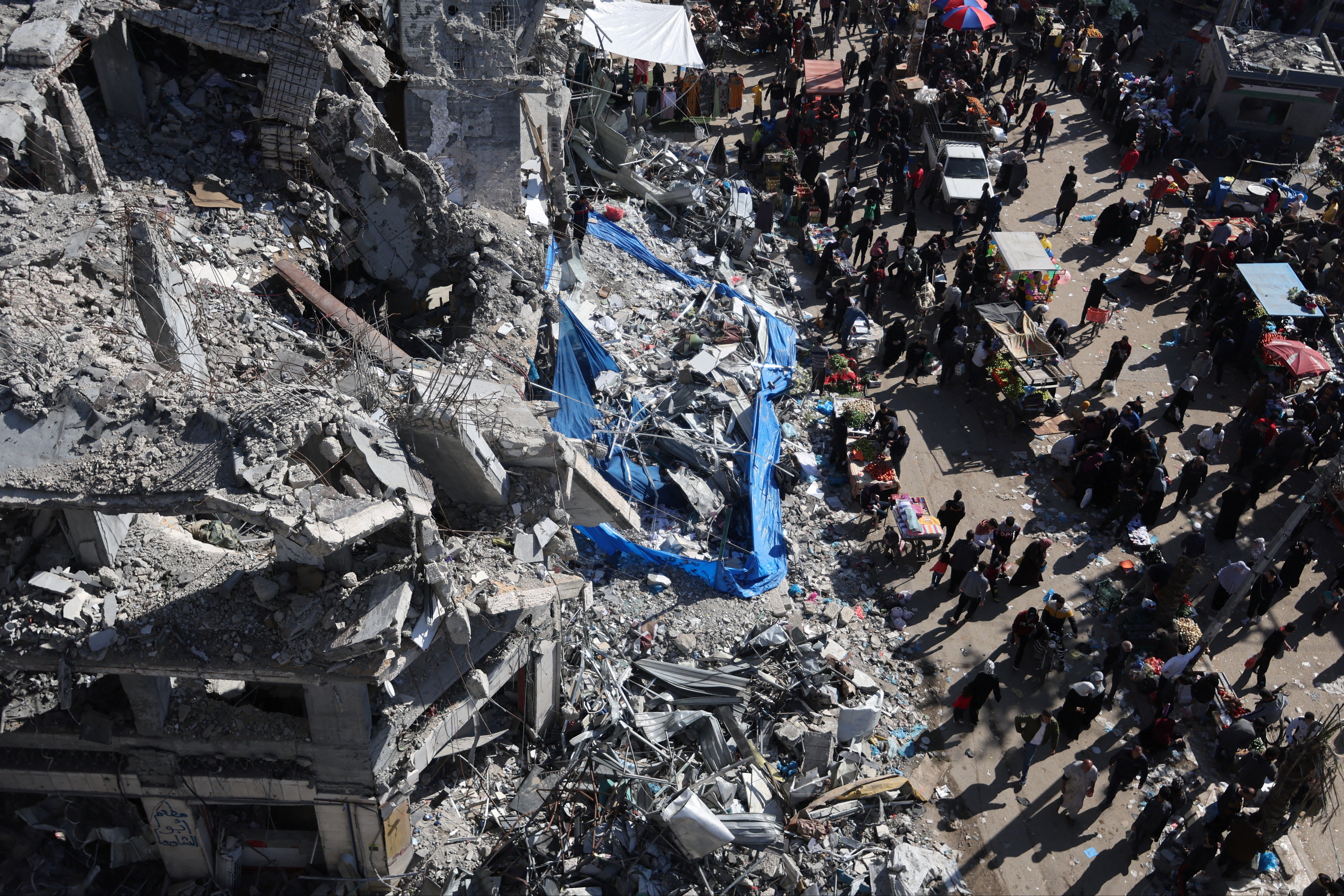 An open-air market among the ruins of houses and buildings destroyed in Israeli strikes, in Nuseirat refugee camp in the central Gaza Strip