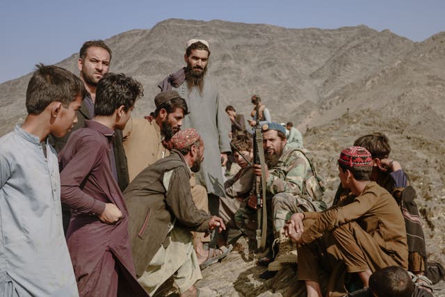 <p>An Afghan refugee group in conversation with Taliban border guards</p>
