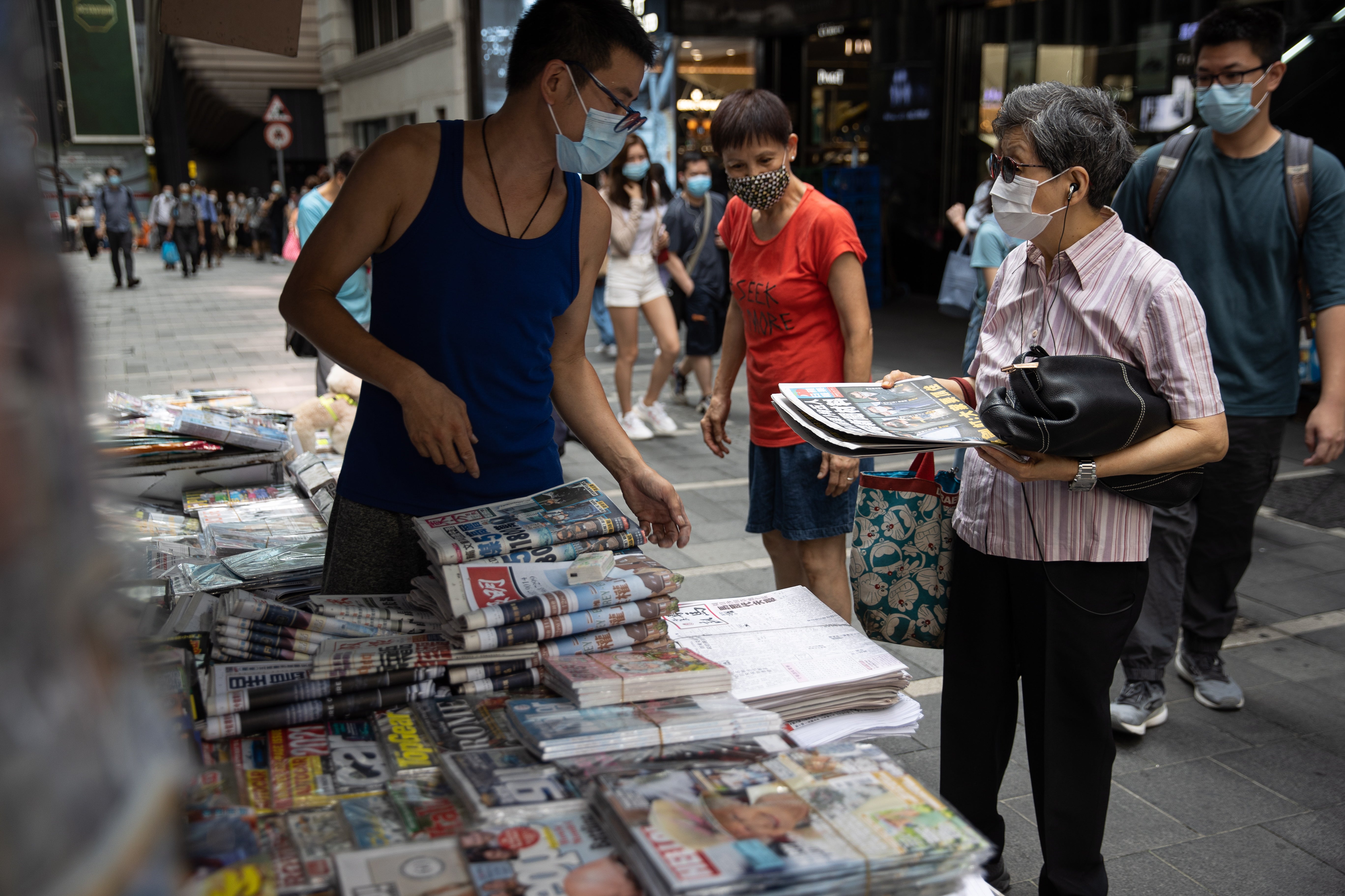 <p>File: A woman buys newspaper at a news stand in Hong Kong, China</p>