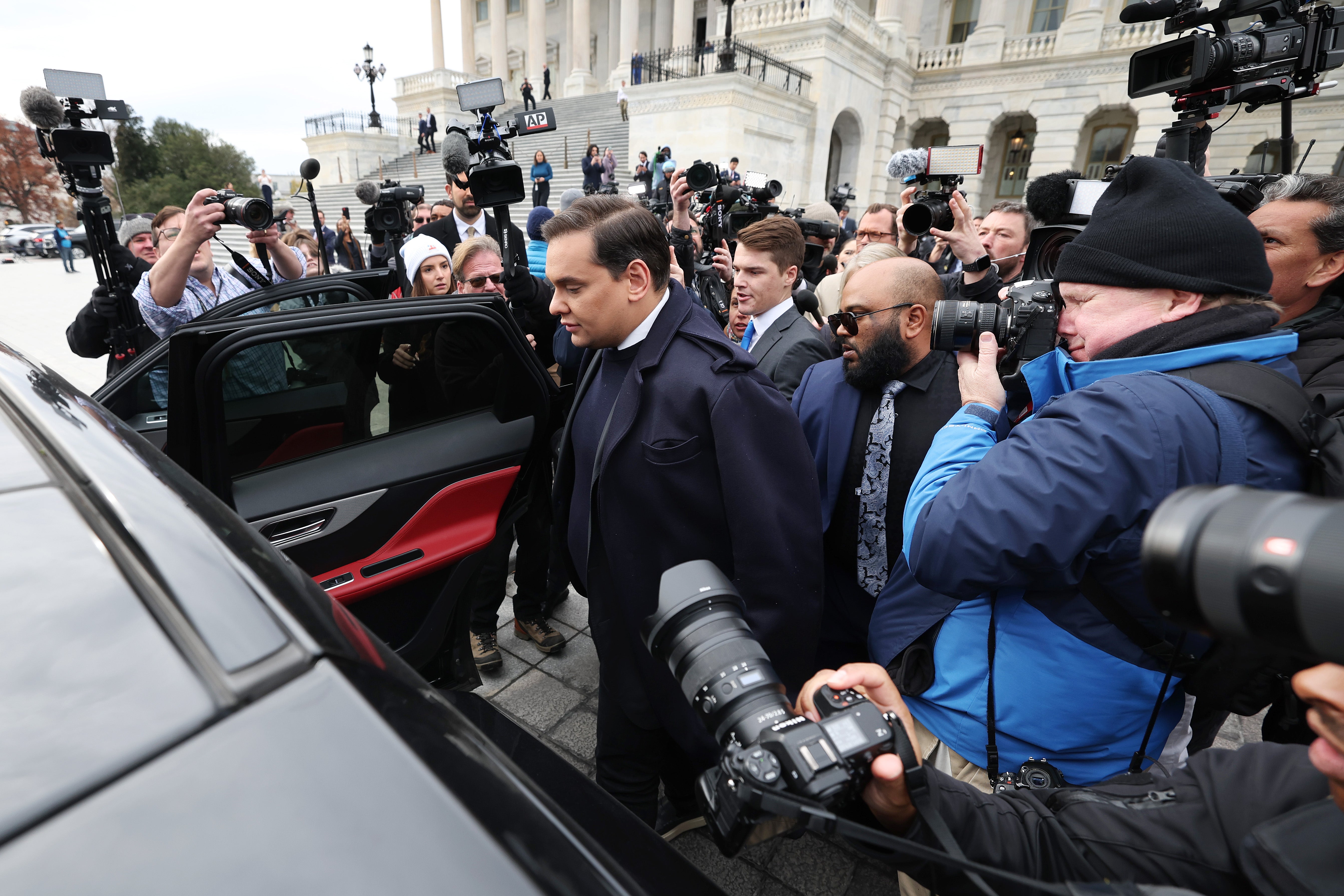 George Santos is surrounded by journalists as he leaves the US Capitol after his fellow members of Congress voted to expel him from the House of Representatives