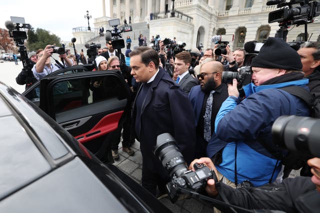 <p>George Santos is surrounded by journalists as he leaves the US Capitol after his fellow members of Congress voted to expel him from the House of Representatives on 1 December</p>