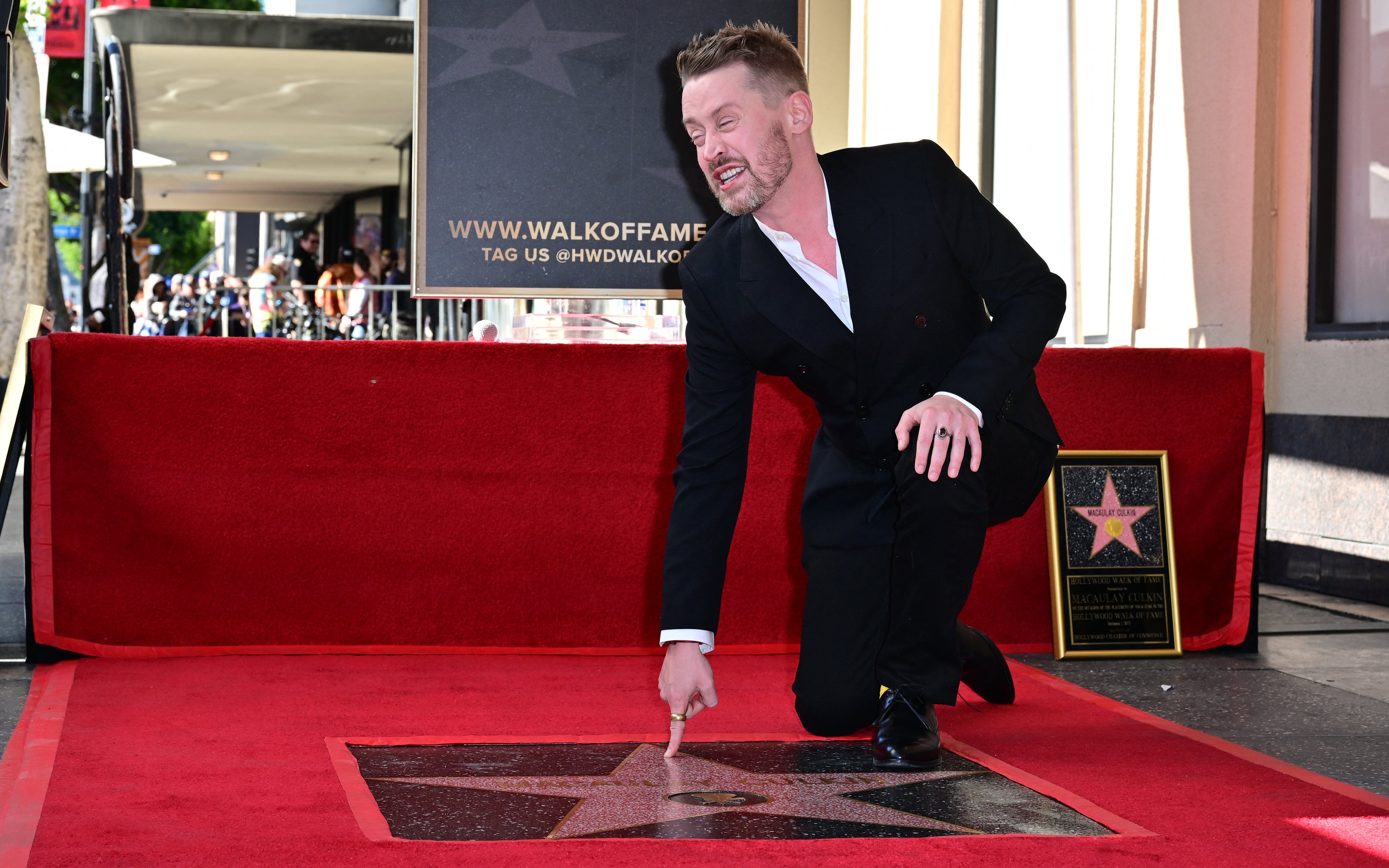 US actor Macaulay Culkin gestures near his newly unveiled Hollywood Walk of Fame Star in Hollywood, California, on December 1, 2023.