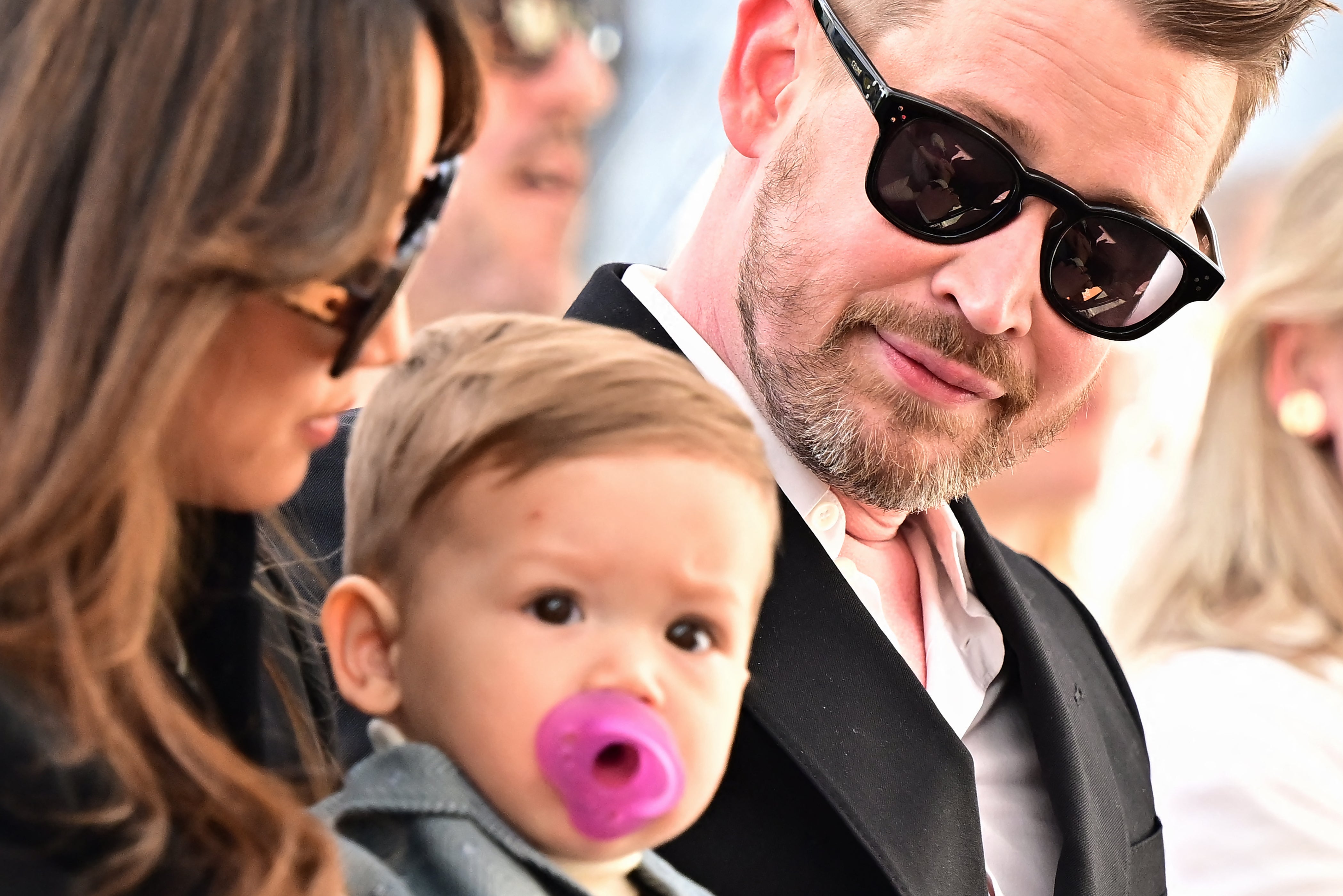 US actor Macaulay Culkin gestures near his partner Brenda Song and their son during a ceremony to unveil his Hollywood Walk of Fame Star on December 1, 2023 in Hollywood.