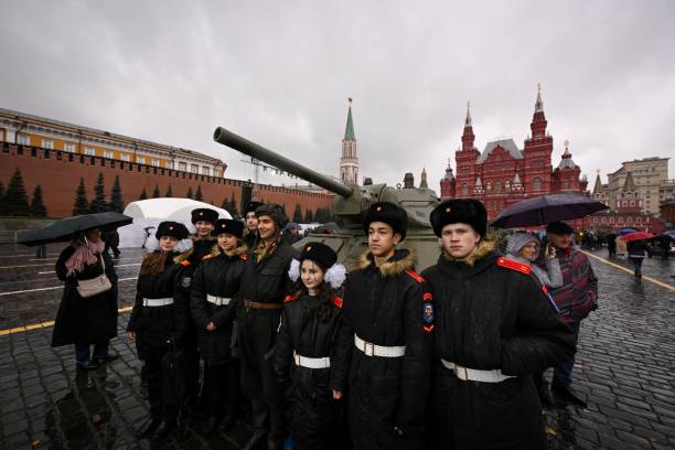 Cadets pose with an artist wearing WWII military uniform at an open air interactive museum at The Red Square in Moscow