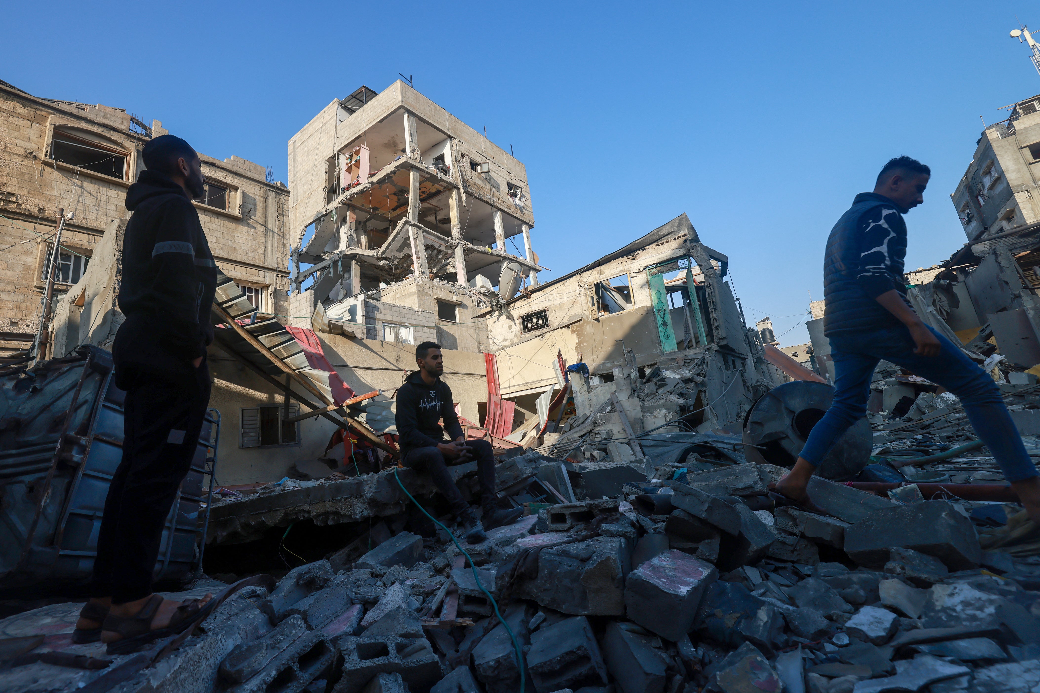 Palestinians inspect a building damaged during Israeli bombardment in Rafah on the southern Gaza Strip