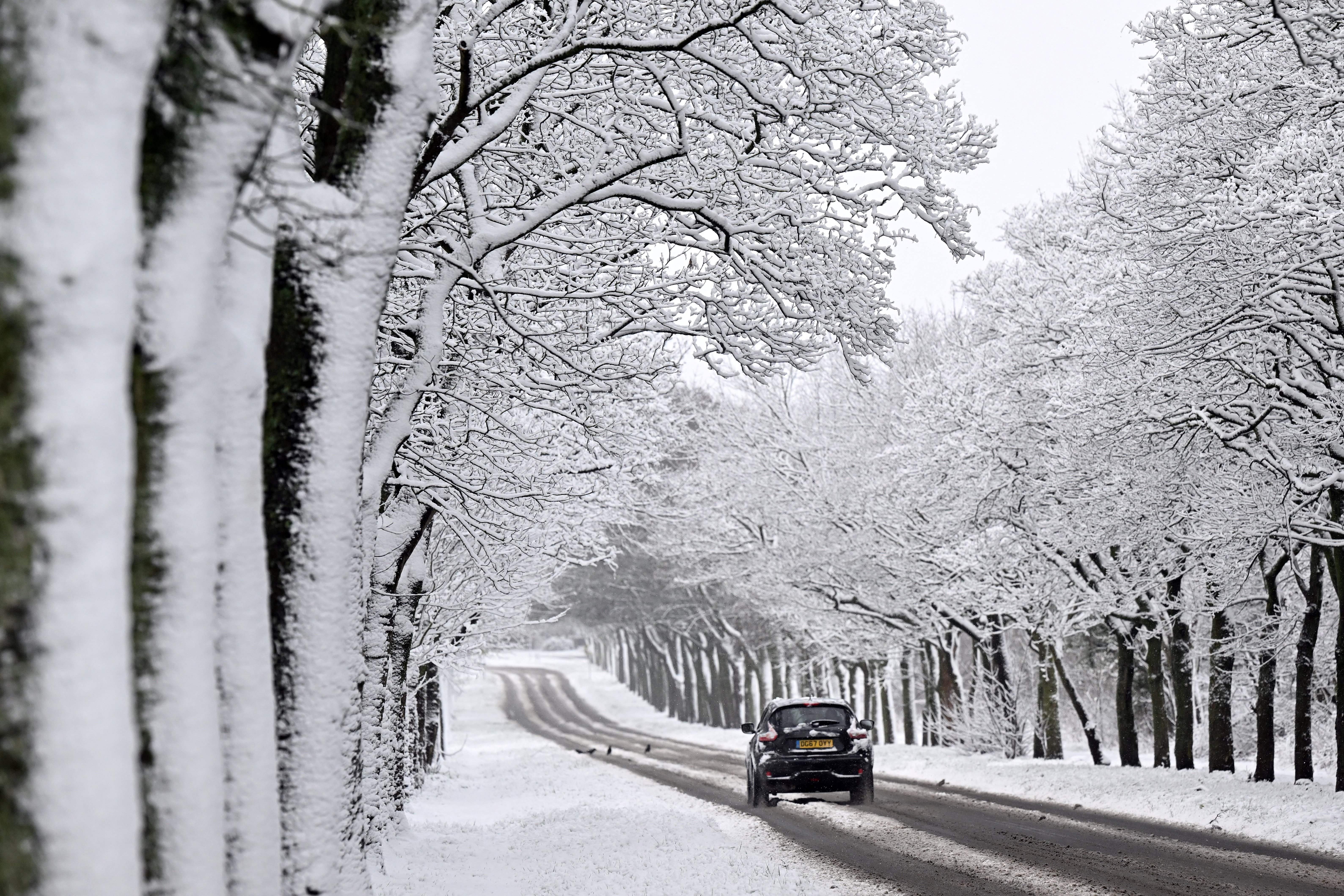 A car drives through the snow near Birkenhead