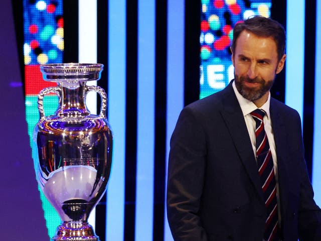 <p>England manager Gareth Southgate looks at the European Championship trophy at the draw in Hamburg</p>