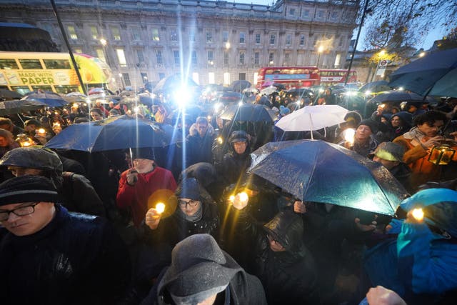 <p>People hold candles during an anti-hate vigil on Whitehall in central London</p>