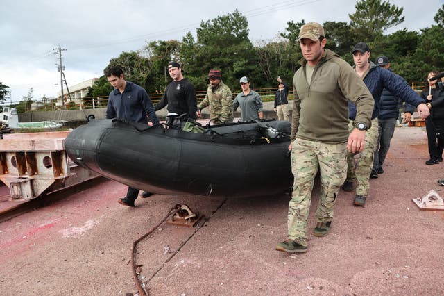 <p>US military personnel carry a dinghy as they head out to search for the crash of a US CV-22B Osprey aircraft, on the island of Yakushima, Kagoshima Prefecture on December 1, 2023</p>