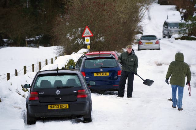 <p>Shoveling snow in Ings, Cumbria. More than 830 properties in the county were still without power after heavy weekend snow </p>