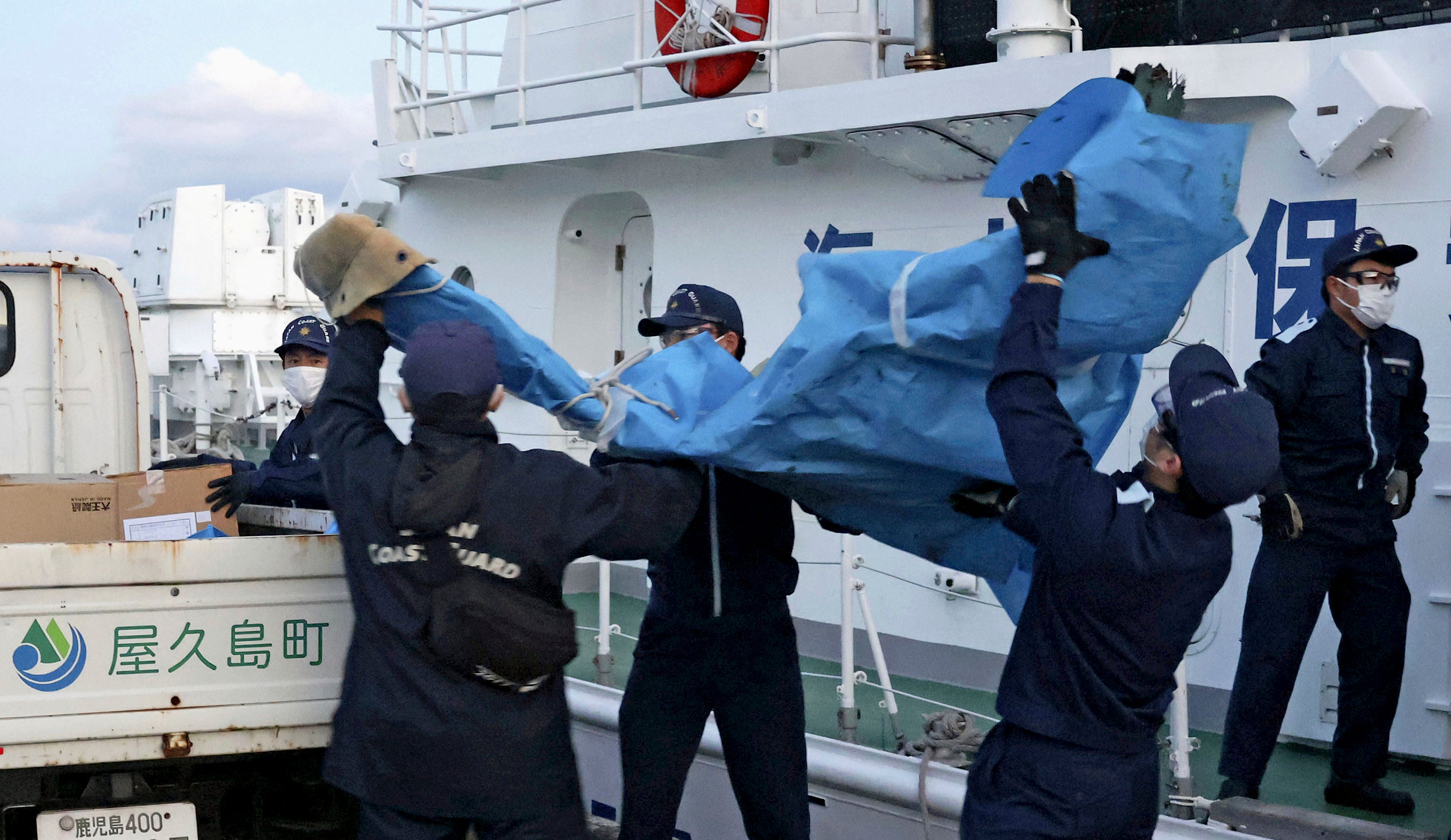 The members of Japanese Coast Guard carry the debris which are believed to be from the crashed U.S. military Osprey aircraft, at a port in Yakushima, Kagoshima prefecture, southern Japan, Monday, Dec. 4, 2023