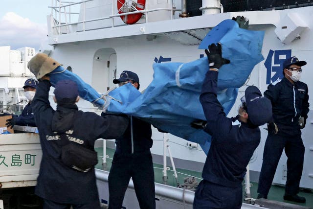 <p>The members of Japanese Coast Guard carry the debris which are believed to be from the crashed US military Osprey aircraft in early December </p>
