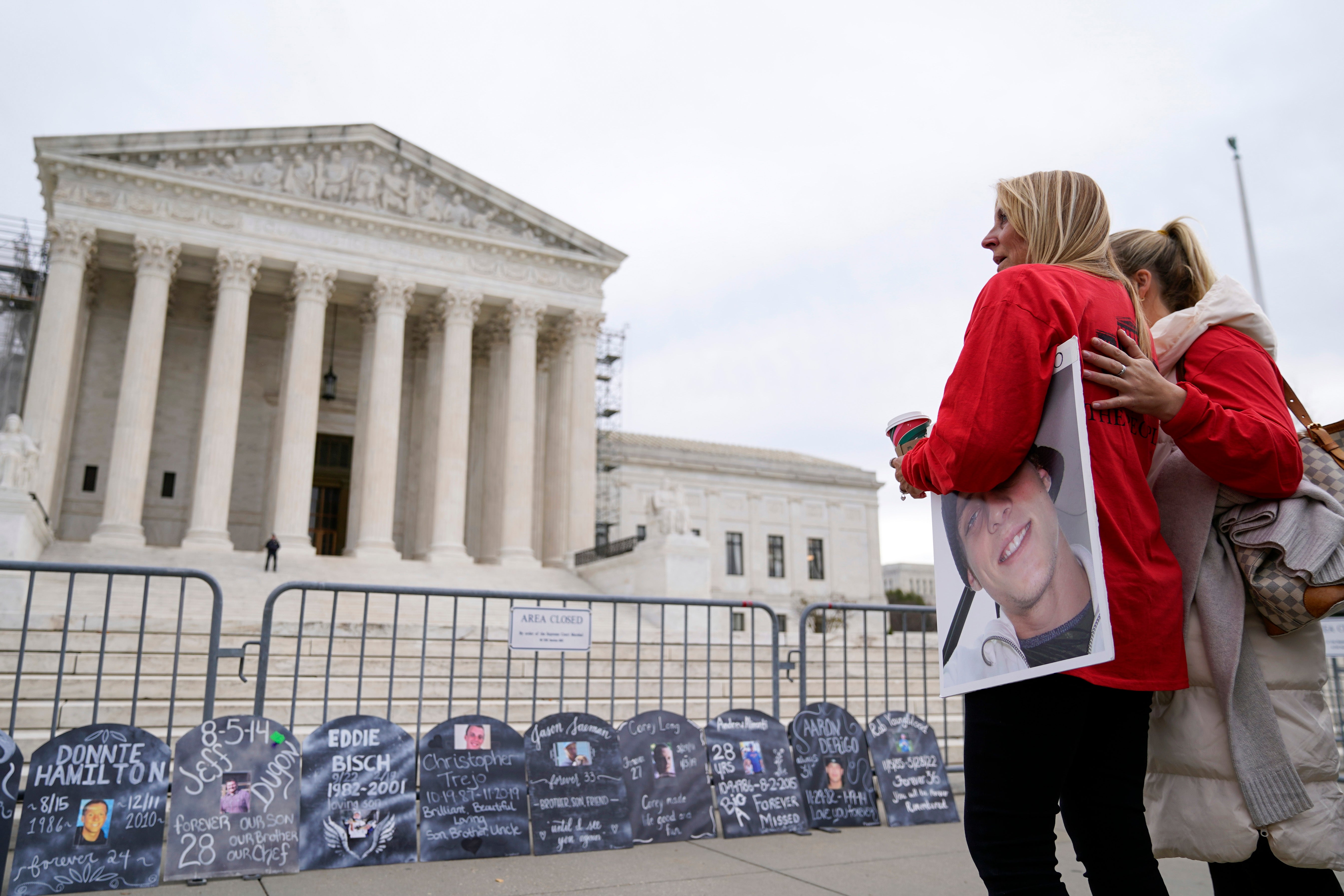 Jen Trejo holds a photo of her son Christopher as she is comforted outside the Supreme Court