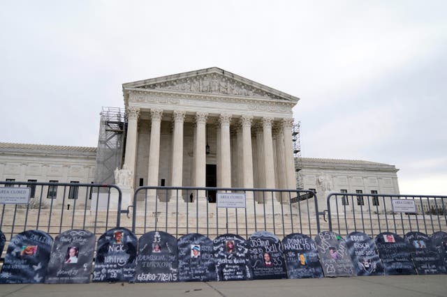 <p>Signs in the shape of grave headstones, with information on people who died from using OxyContin, line a security fence outside the Supreme Court Monday, Dec. 4, 2023</p>