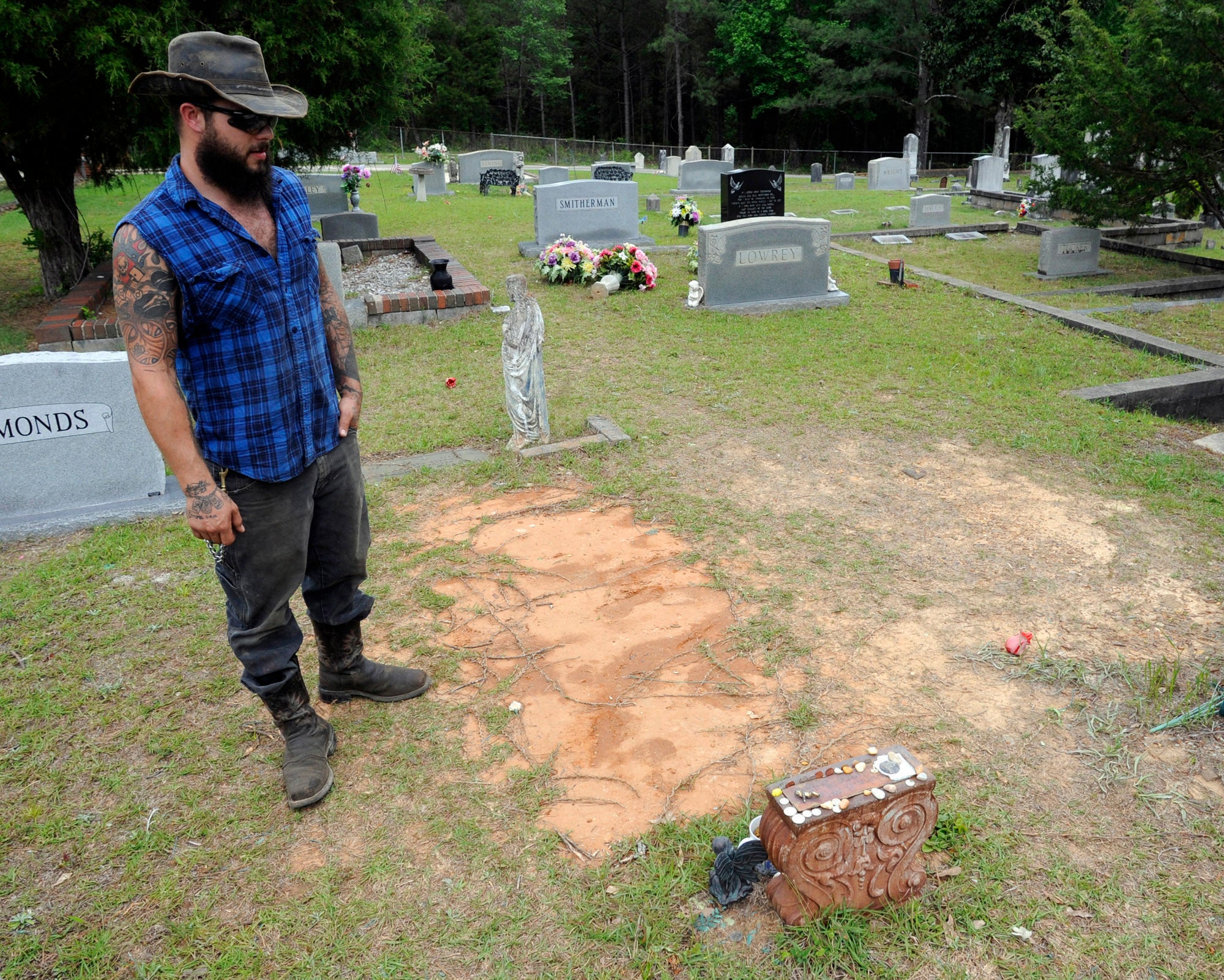 Tyler Goodson of the hit podcast S-Town stands at the grave in Green Pond, Ala., of his late friend John B. McLemore, who is also featured in the show, on May 3, 2017