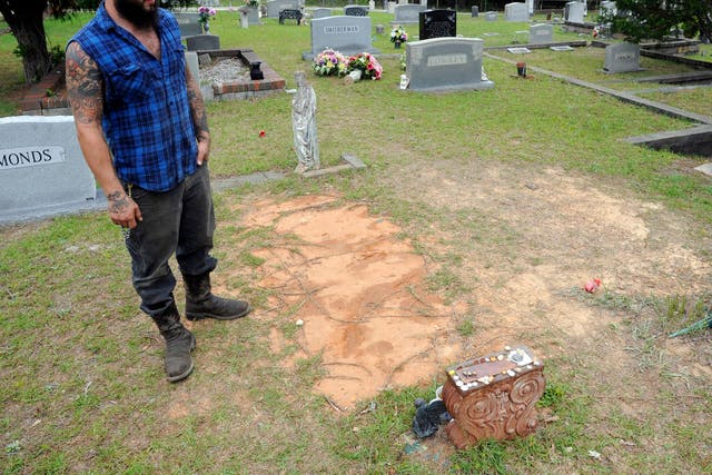 <p>Tyler Goodson of the hit podcast S-Town stands at the grave in Green Pond, Ala., of his late friend John B. McLemore, who is also featured in the show, on May 3, 2017</p>