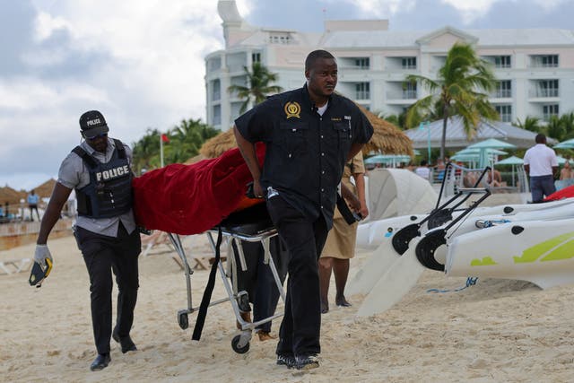 <p>Mortuary services personnel transport the body of a female tourist after what police described as a fatal shark attack in waters near Sandals Royal Bahamian resort, in Nassau, Bahamas</p>