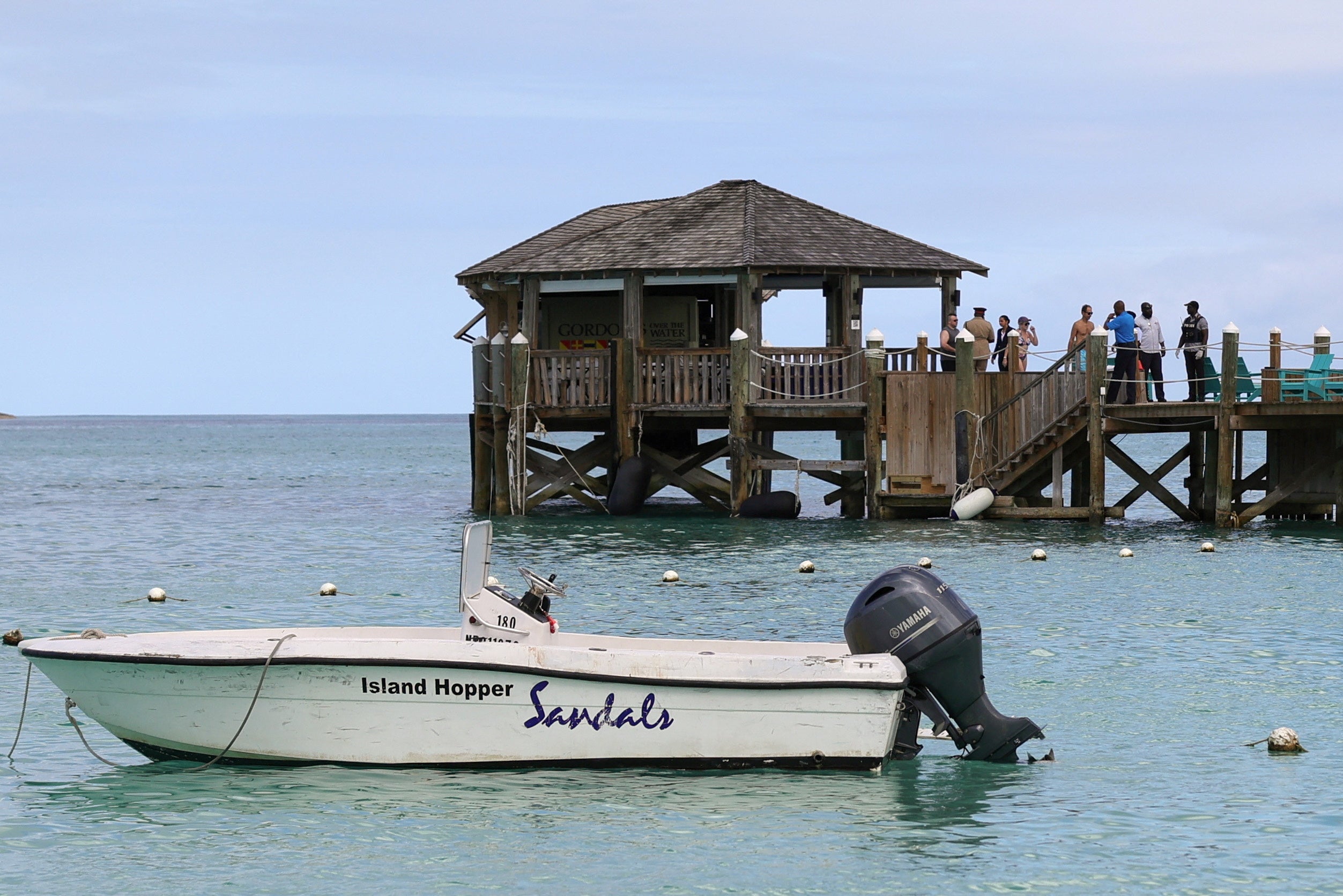 People gather on the resort pier after the shark attack at Sandals Royal Bahamian resort