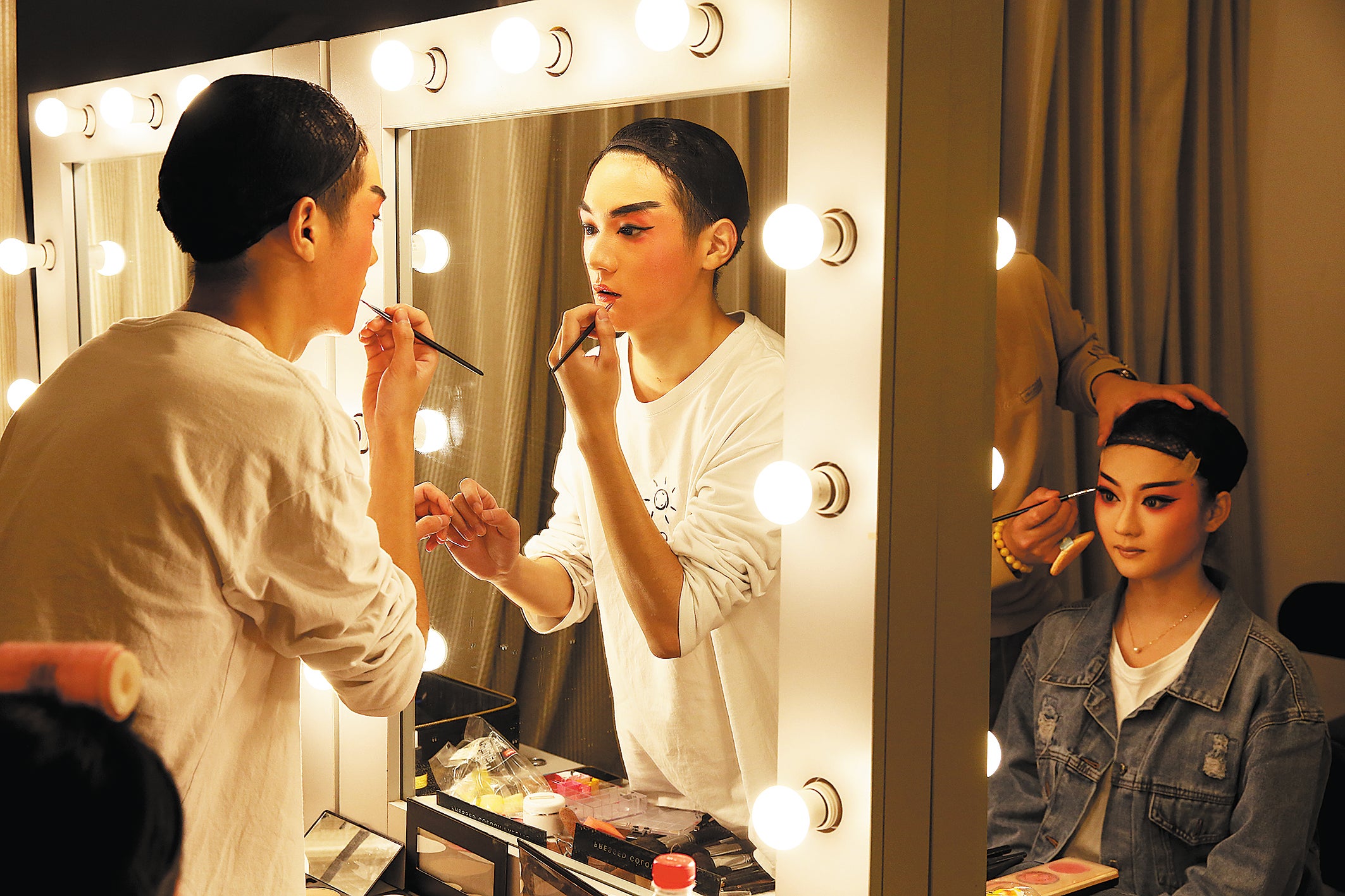Actors put on makeup before a performance at a theatre in Anqing