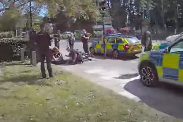 A screenshot of a video showing a Northants Pc using a borrowed bike to arrest a suspect. (Northants Police/PA)