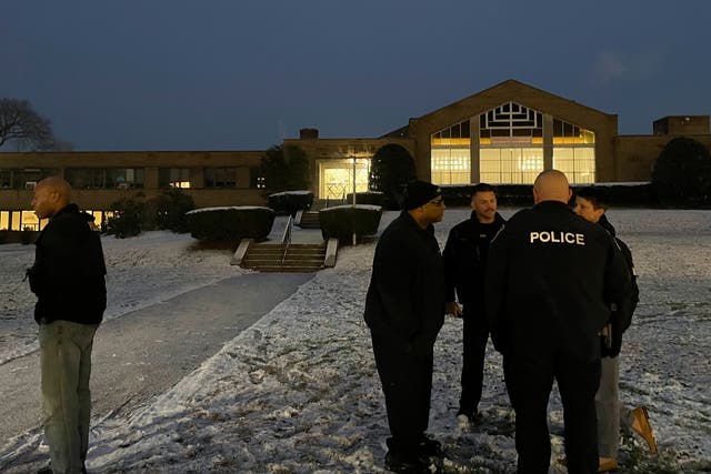 <p>Albany police officers gather outside Temple Israel, Thursday, Dec. 7, 2023, in Albany, N.Y, where a 28-year-old suspect was arrested for allegedly firing two rounds from a shotgun outside the Jewish temple </p>