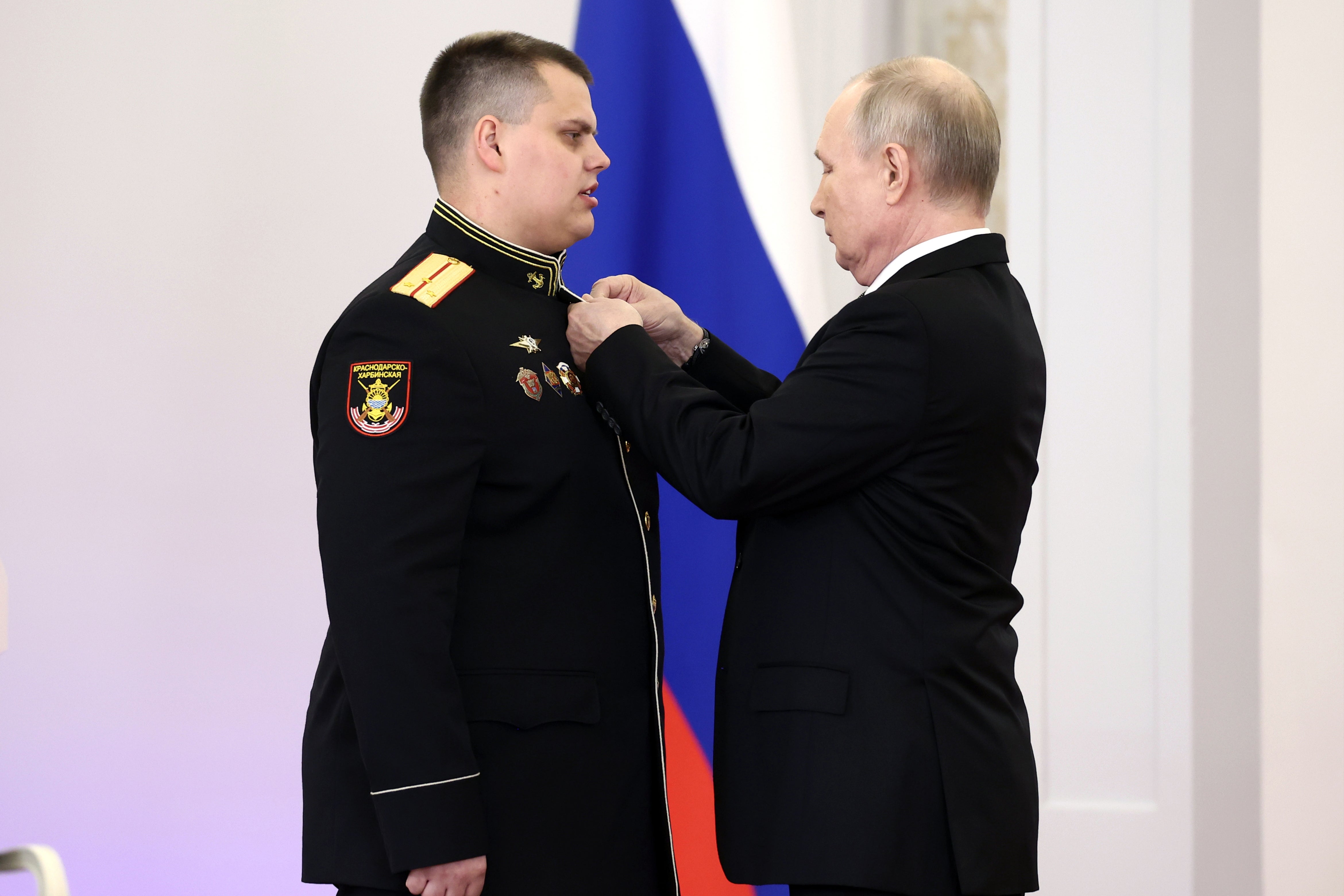 Putin presents Senior Lieutenant Eduard Kazimov with a medal at the Grand Kremlin Palace yesterday