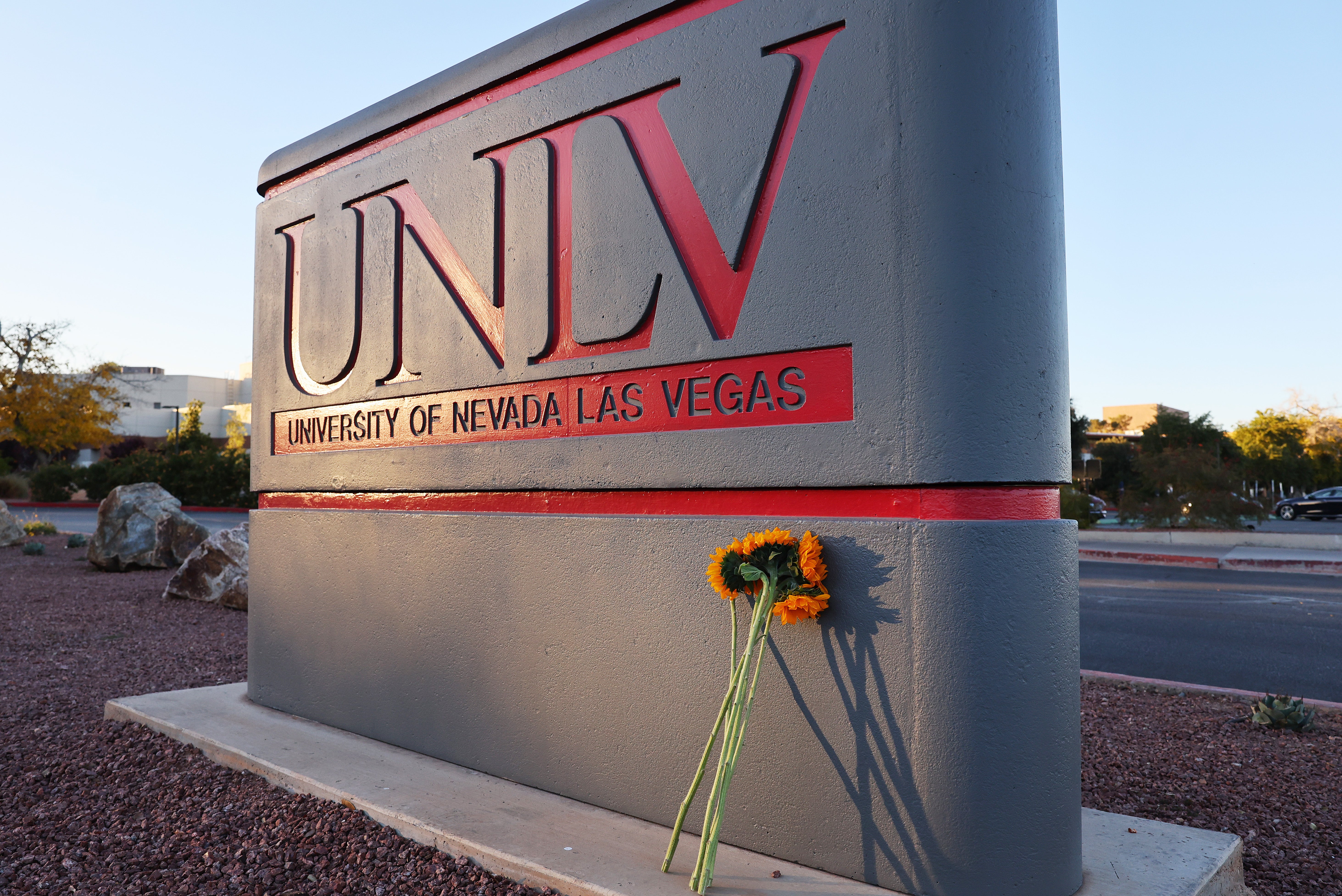 Flowers rest against a UNLV campus sign after a mass shooting in December 2023 left three dead. The university is one of 45 institutions being investigated by the Department of Education over its DEI programs