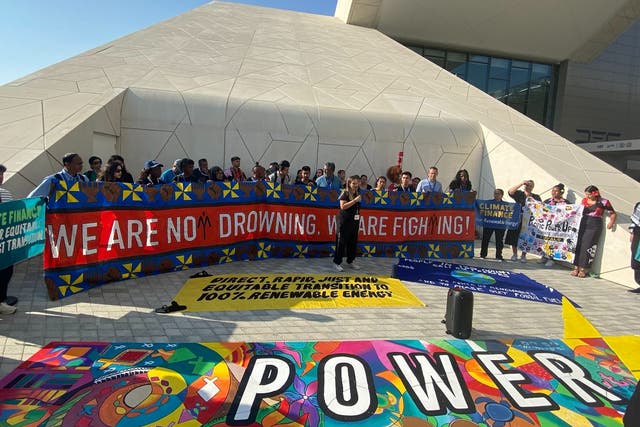 <p>Climate activists demand a global ‘power-up’ of renewables and phase out of fossil fuels to keep 1.5C in reach at the Cop28 venue in Dubai, United Arab Emirates, on Friday</p>