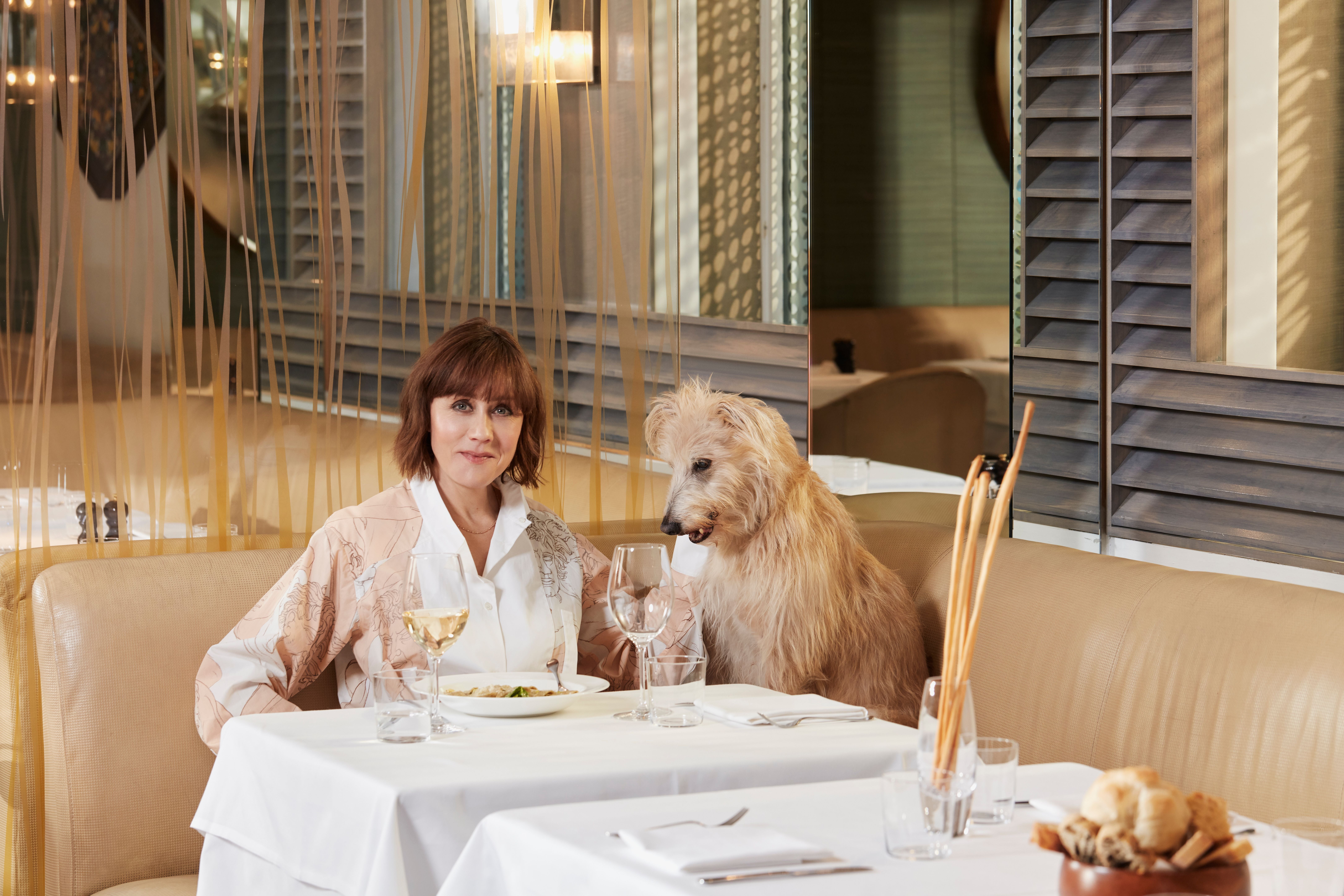 <p>Kate Spicer dining with her dog, Wolfy</p>