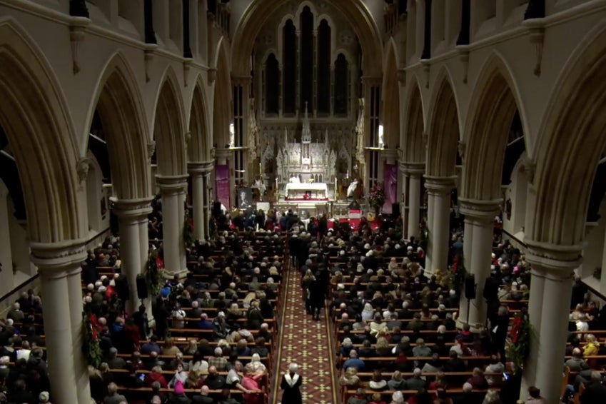 Mourners take communion during the service