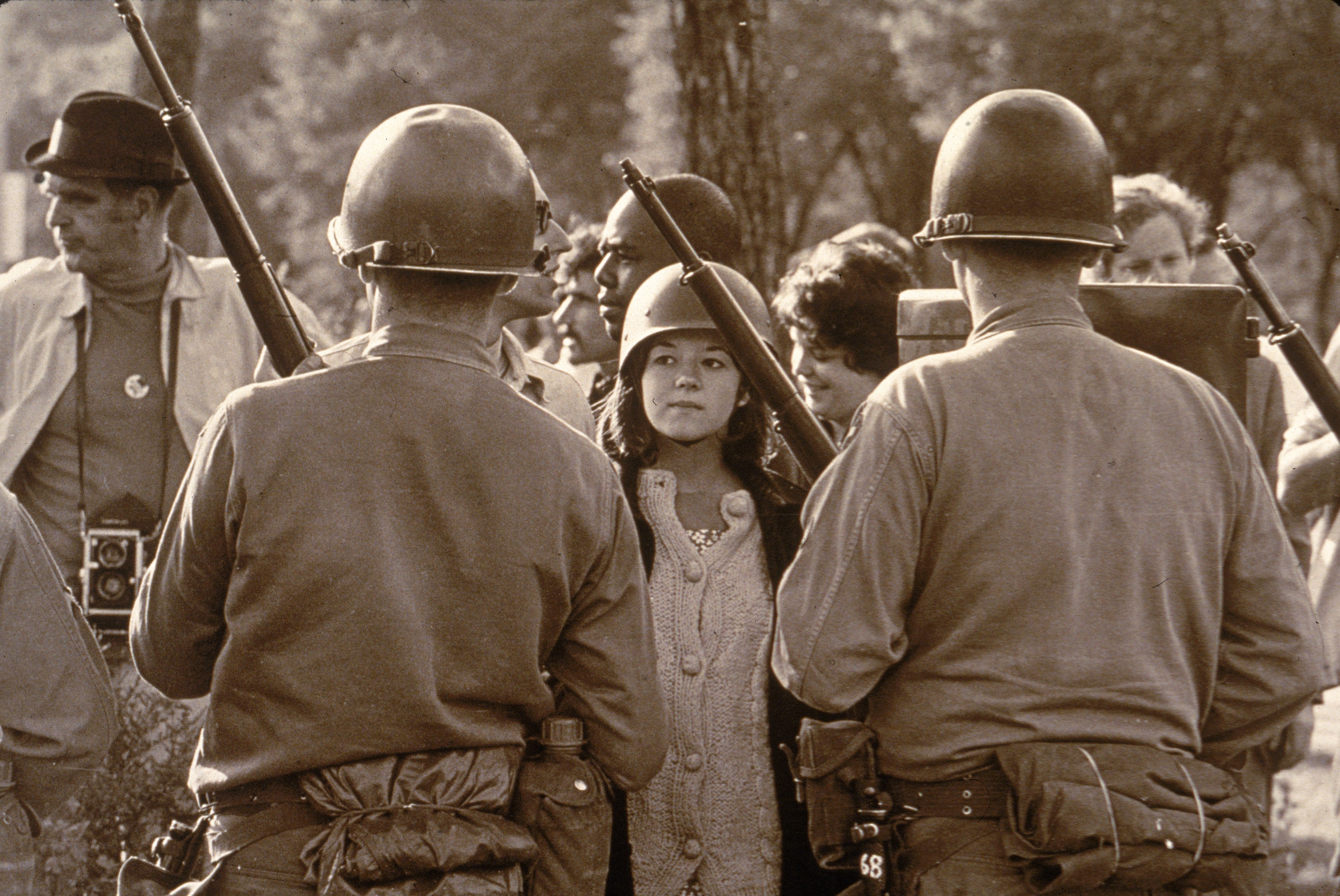 A young female protester wearing faces down helmeted and armed police officers at an anti-Vietnam War demonstration outside the 1968 Democratic National Convention in Chicago, Illinois, during August 1968