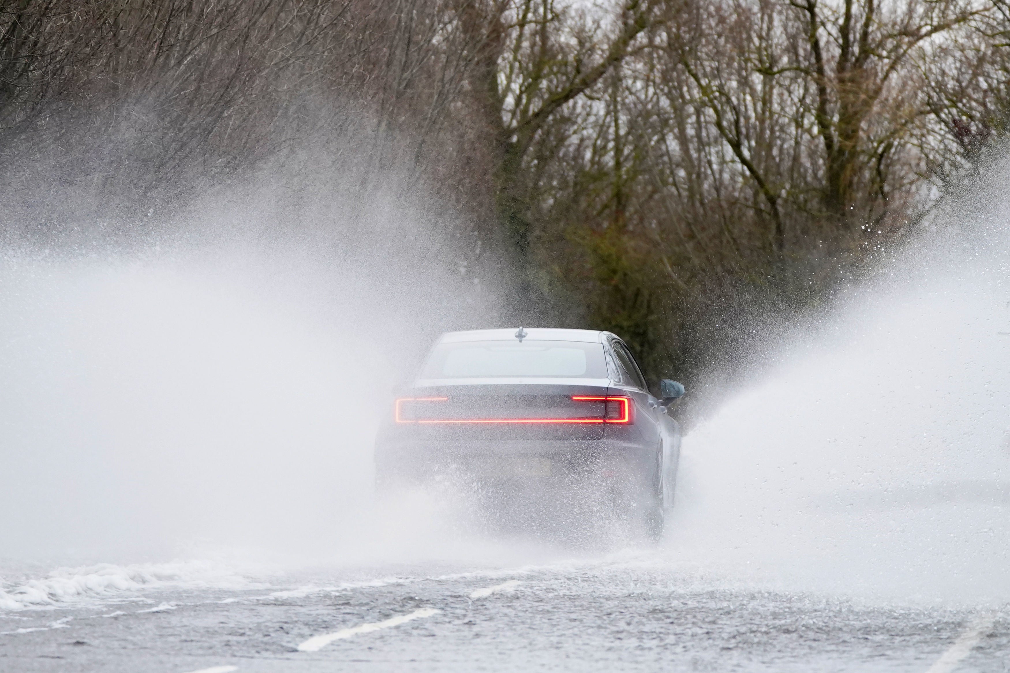 Cars make their way through surface water on the A1101 in Welney in Norfolk on 7 December 2023