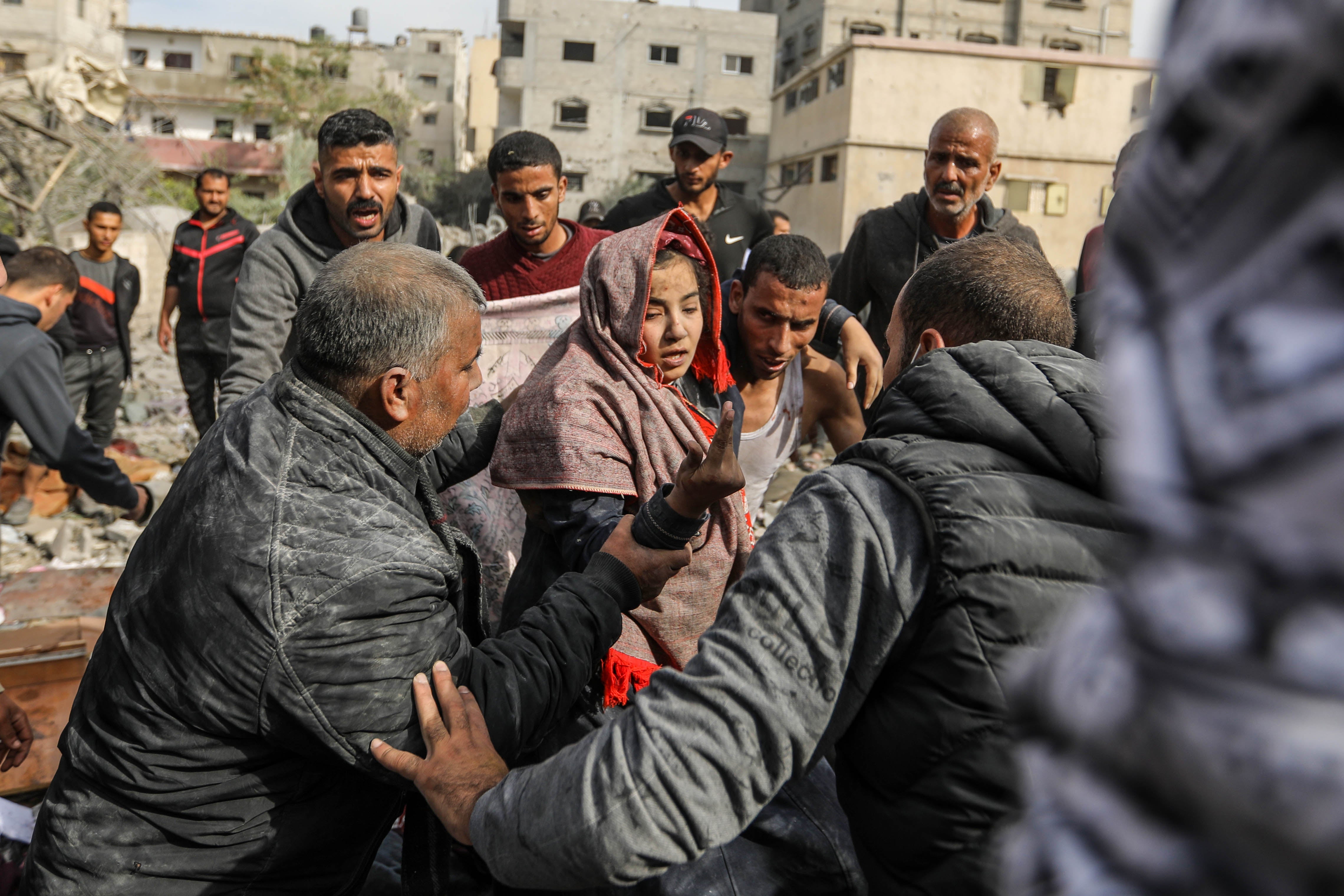 Palestinian citizens carry out search and rescue operations in the destruction caused by Israeli air strikes on December 07, 2023 in Khan Yunis, Gaza