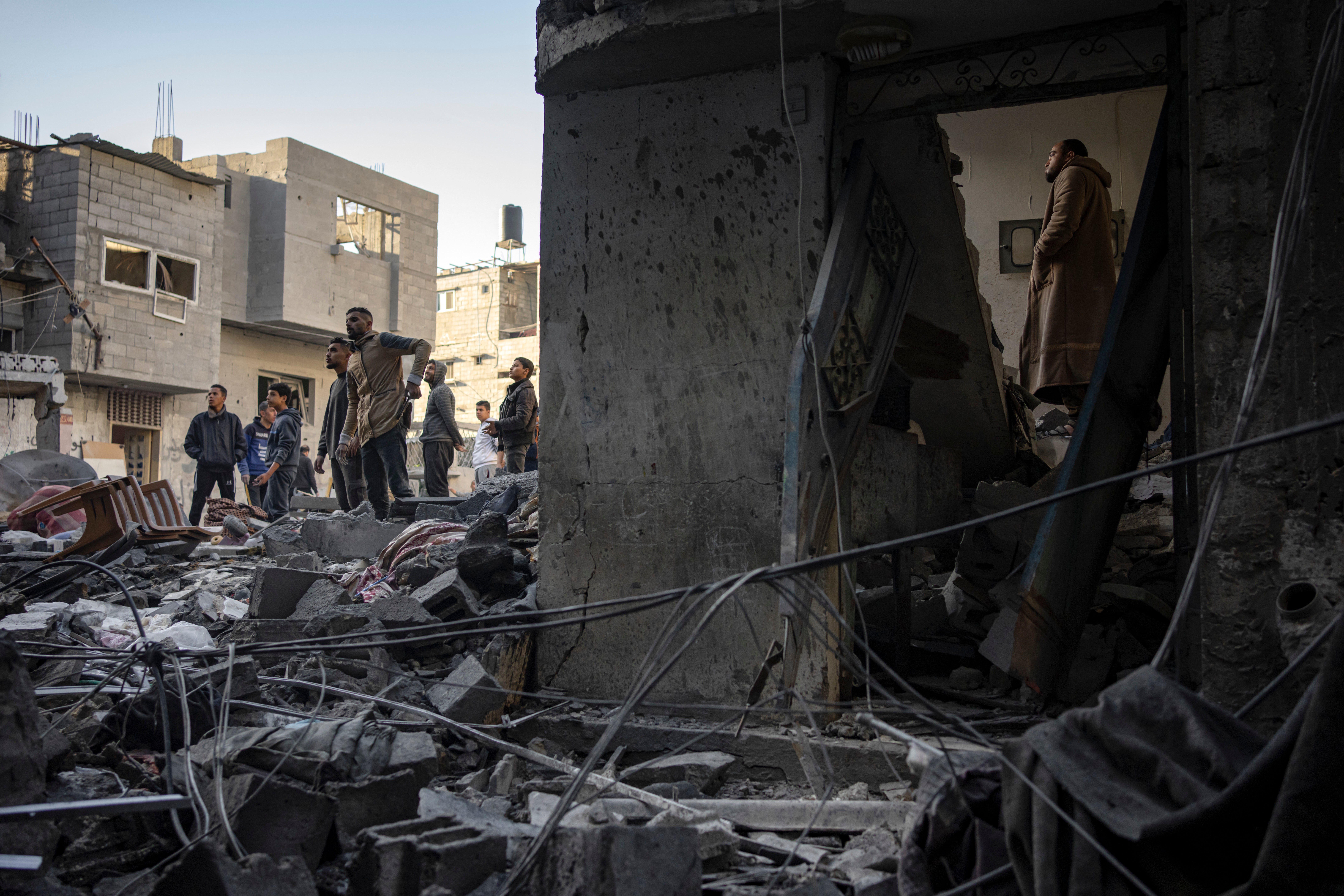 Palestinians look at houses destroyed in the Israeli bombardment of the Gaza Strip