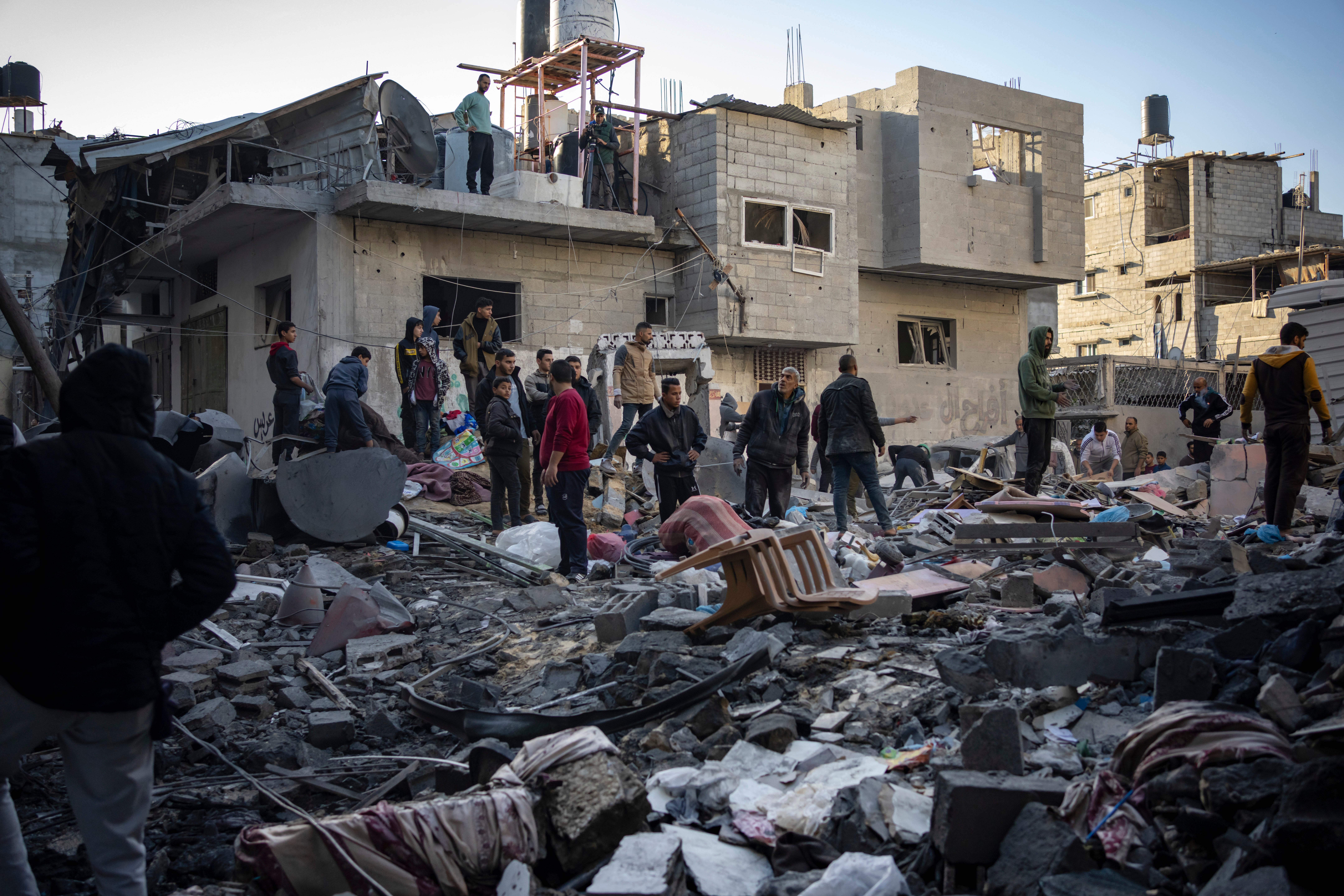 Palestinians look at houses destroyed in the Israeli bombardment of the Gaza Strip in Rafah