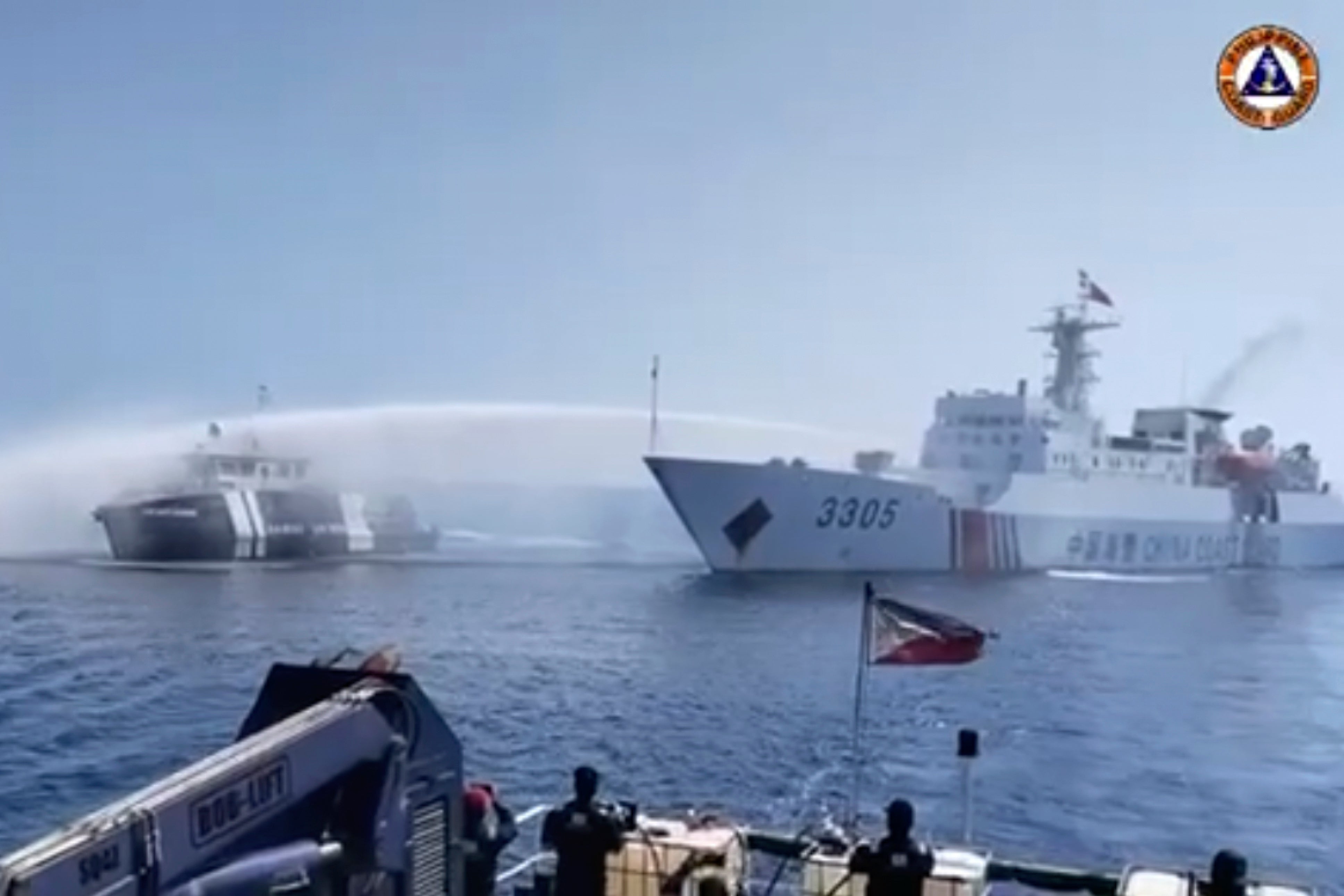 In this image taken from video provided by the Philippine Coast Guard, a Chinese Coast Guard ship, right, uses a water cannon on a Philippine Bureau of Fisheries and Aquatic Resources (BFAR) vessel as it approaches Scarborough Shoal in the disputed South China Sea on Saturday 9 December2023