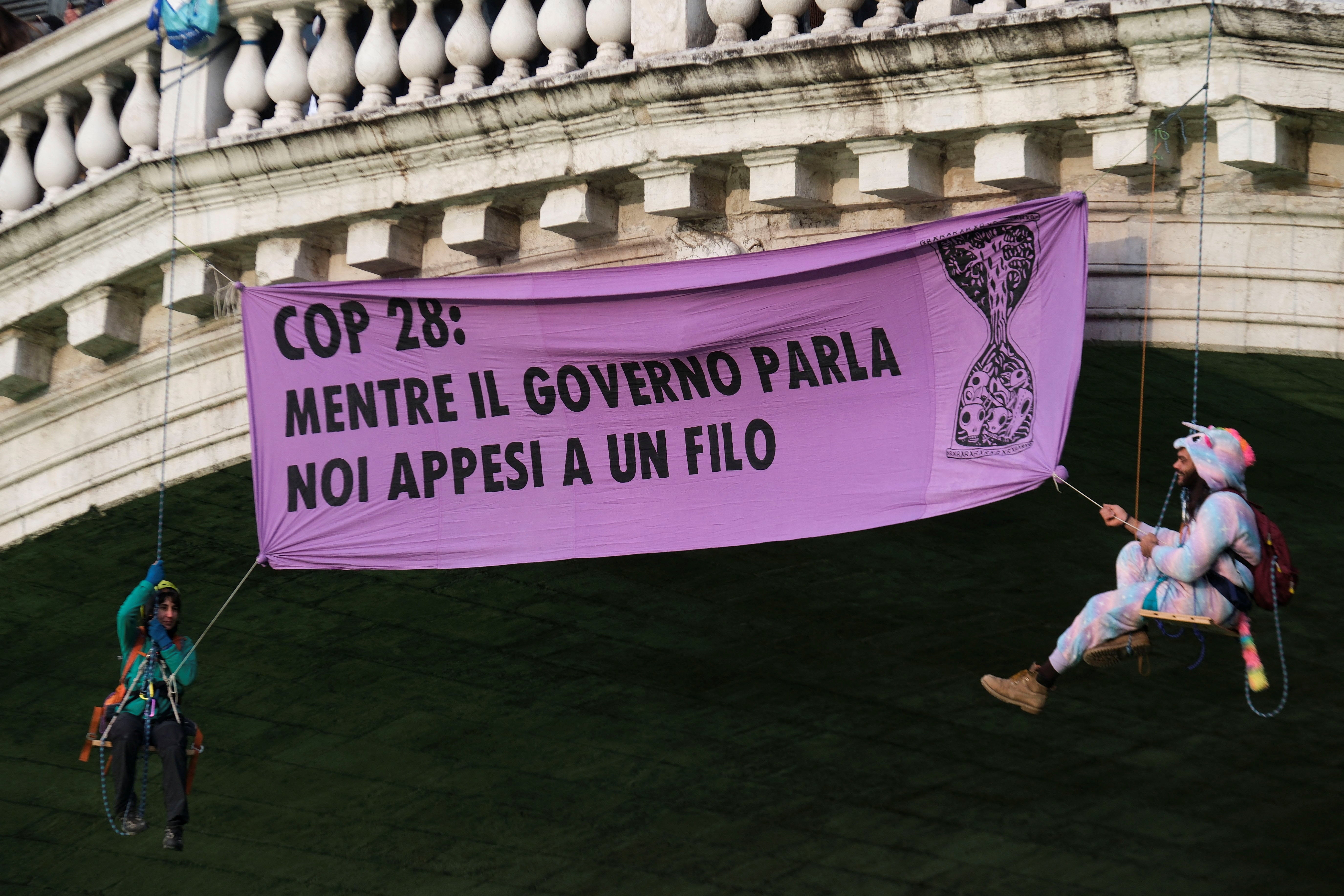 Extinction Rebellion activists dangle from the Rialto Bridge alongside their banner