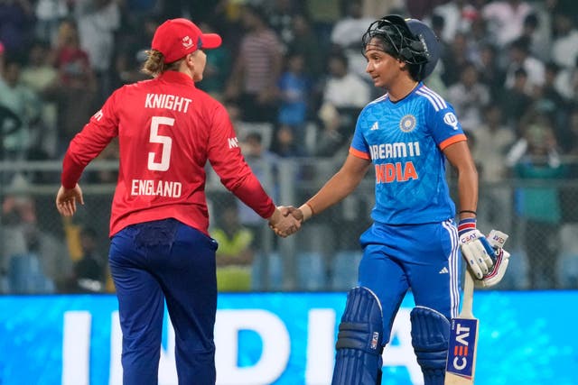 India captain Harmanpreet Kaur (right) shakes hands with England captain Heather Knight after India won the final match of their T20 series (Rajanish Kakade/AP)